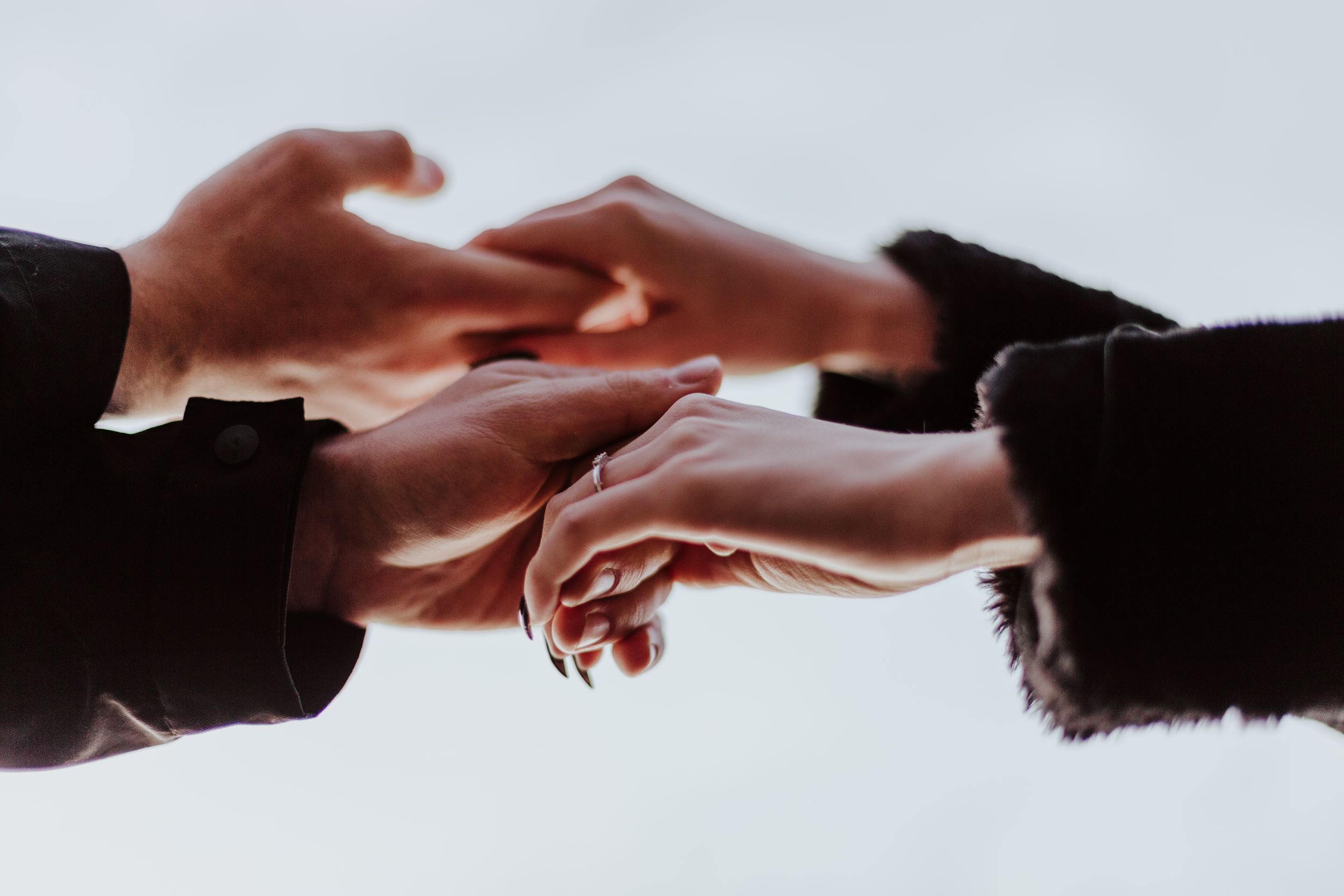 Two people hold each other's hands.