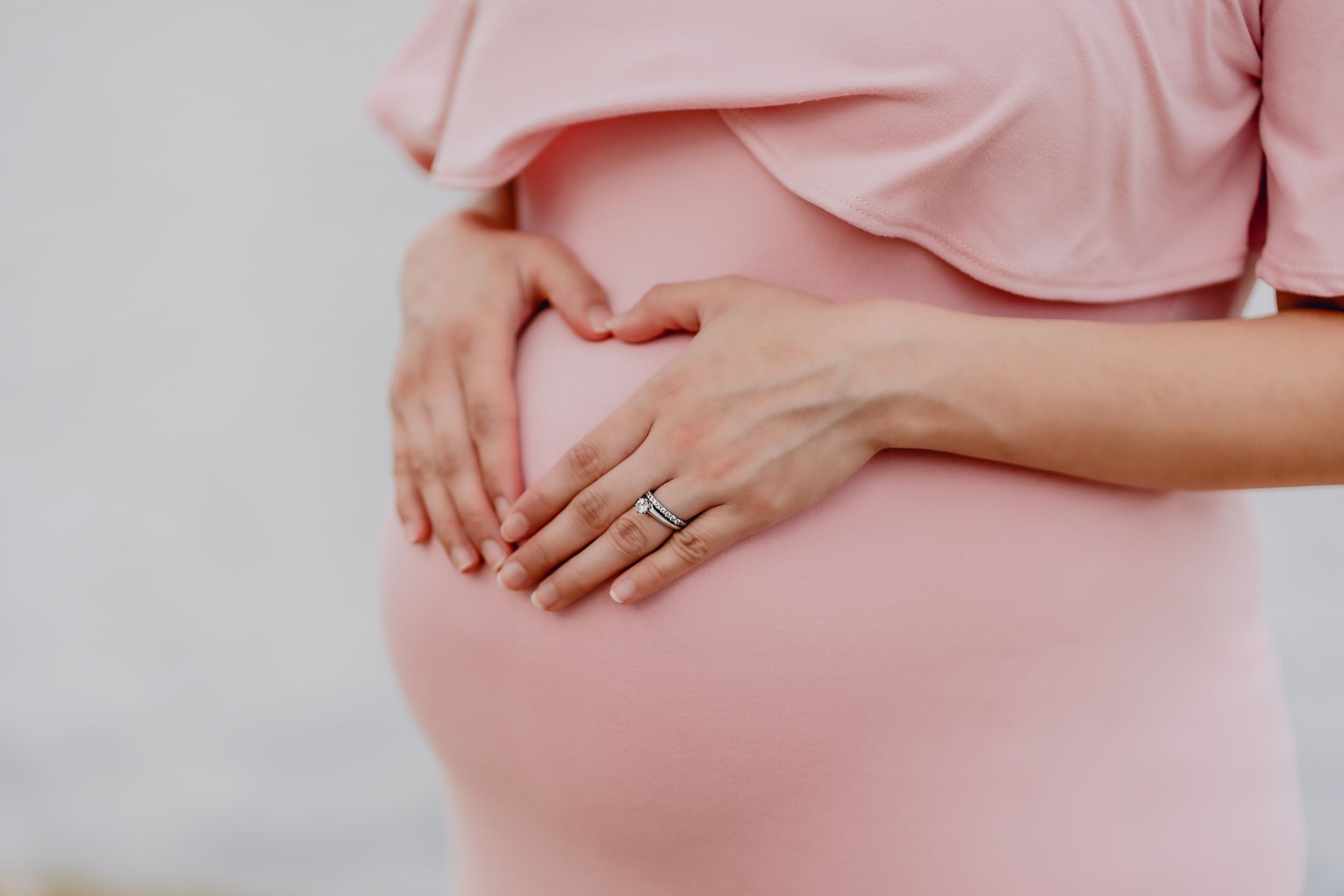 A pregnant woman holds her baby bump.