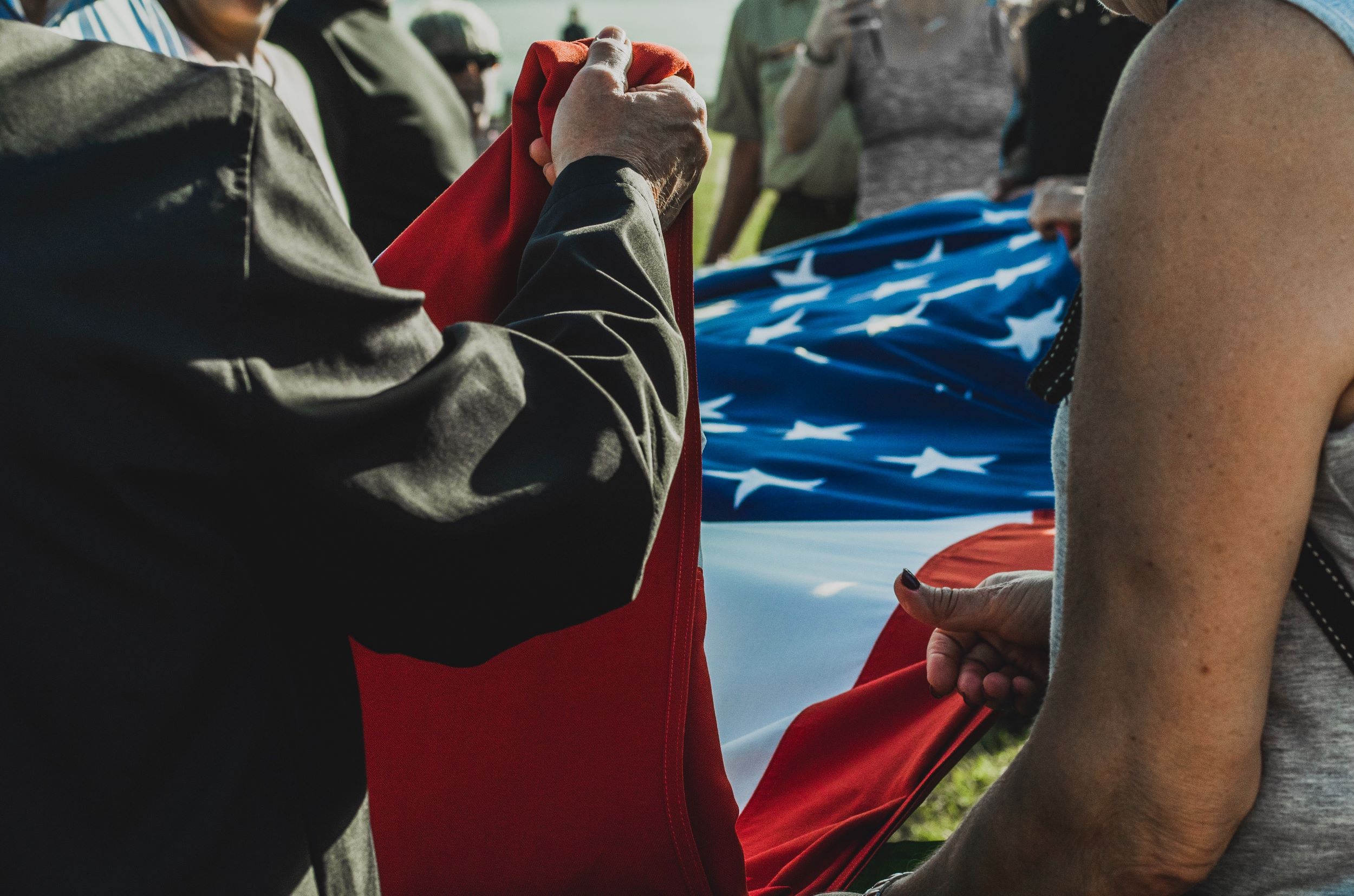 A group of men fold an American Flag.