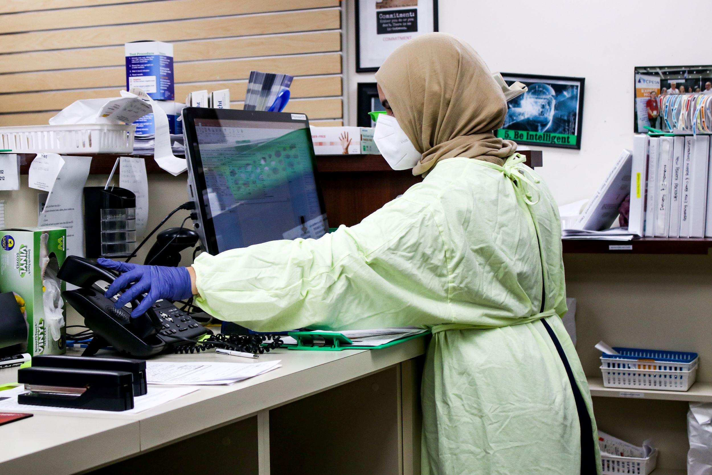 A nurse works in the receptionist area.