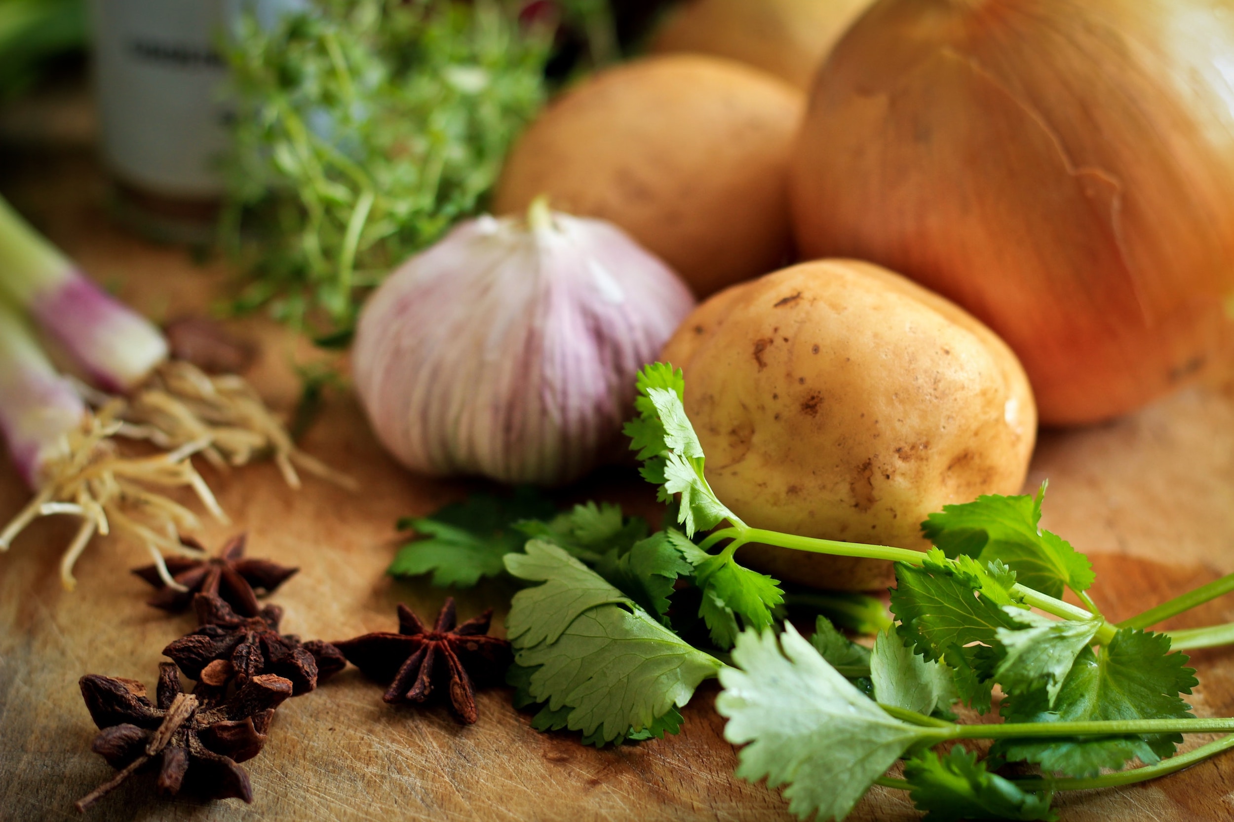 Fresh vegetables are positioned on a wooden block.