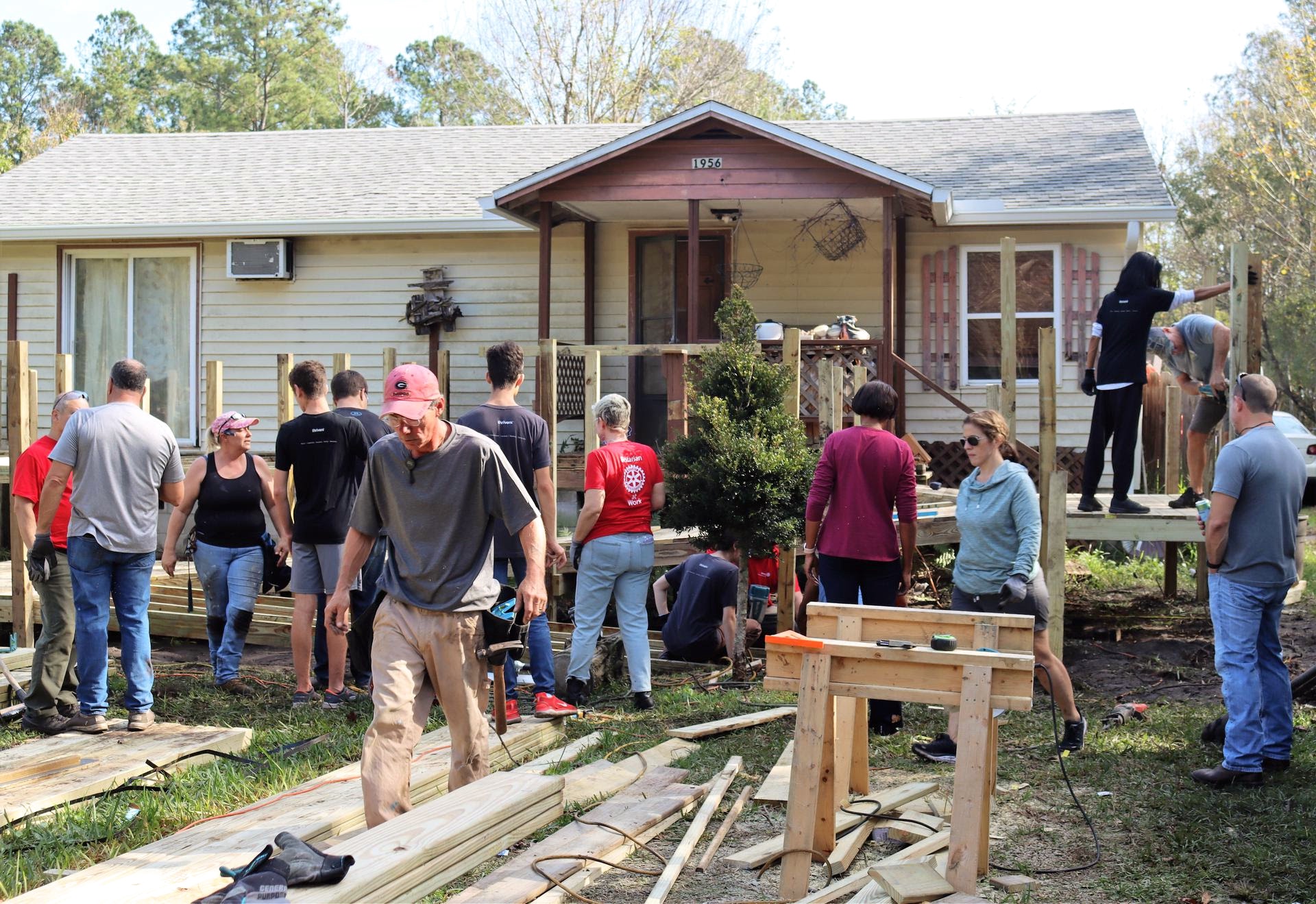 A group of volunteers assist with repairing a house.