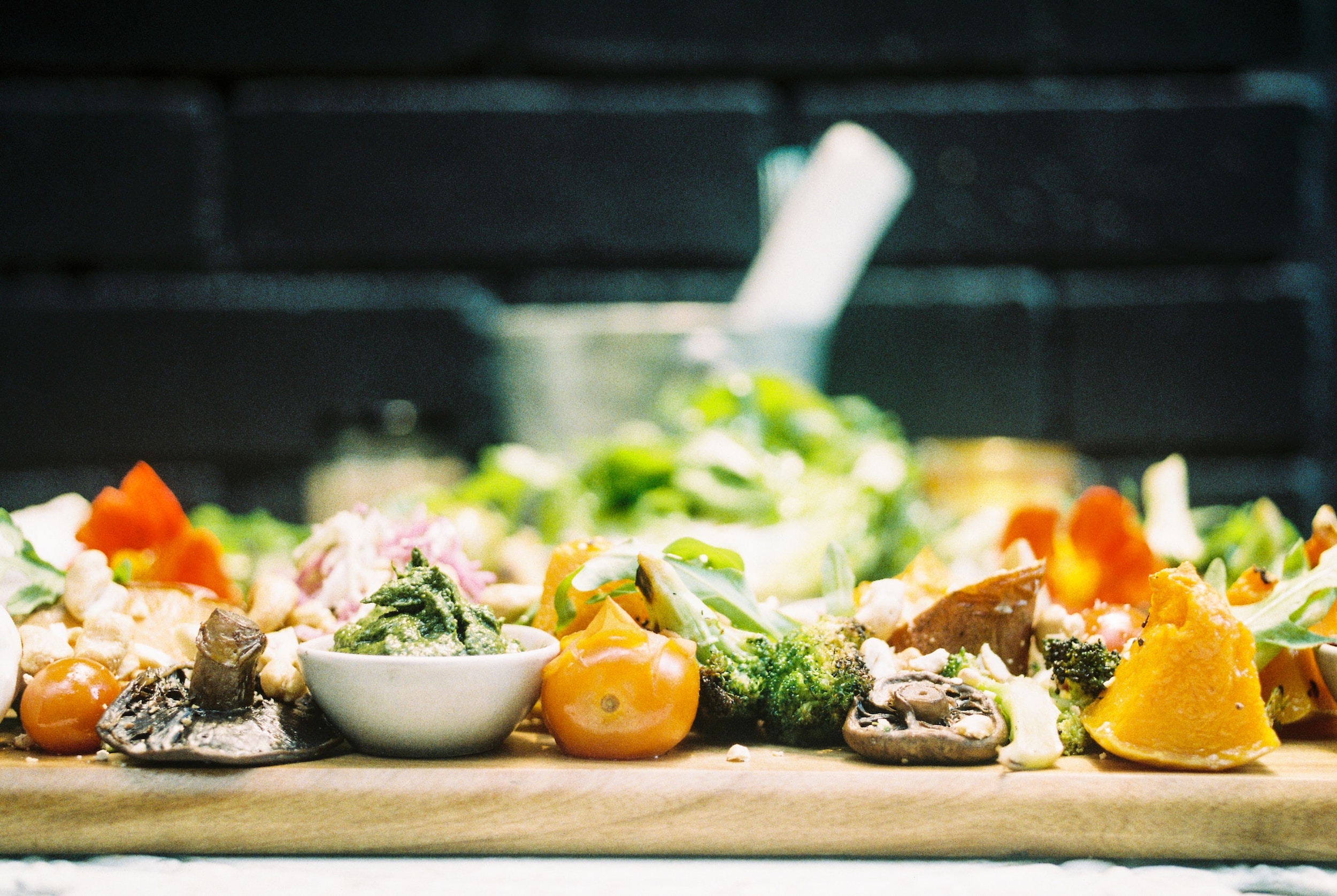 Sliced vegetables are positioned on a wooden board. 