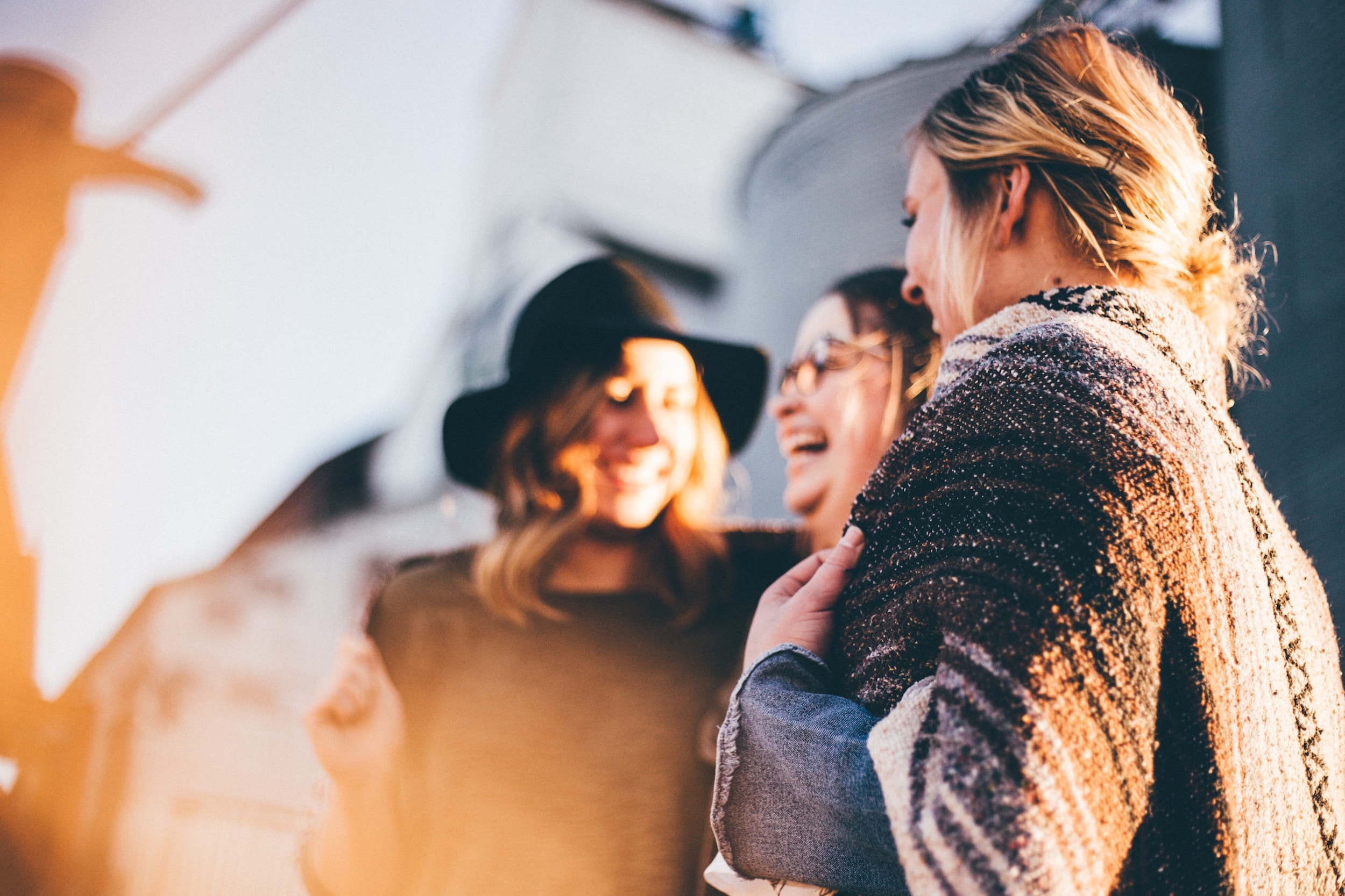A group of women smile and have a conversation.