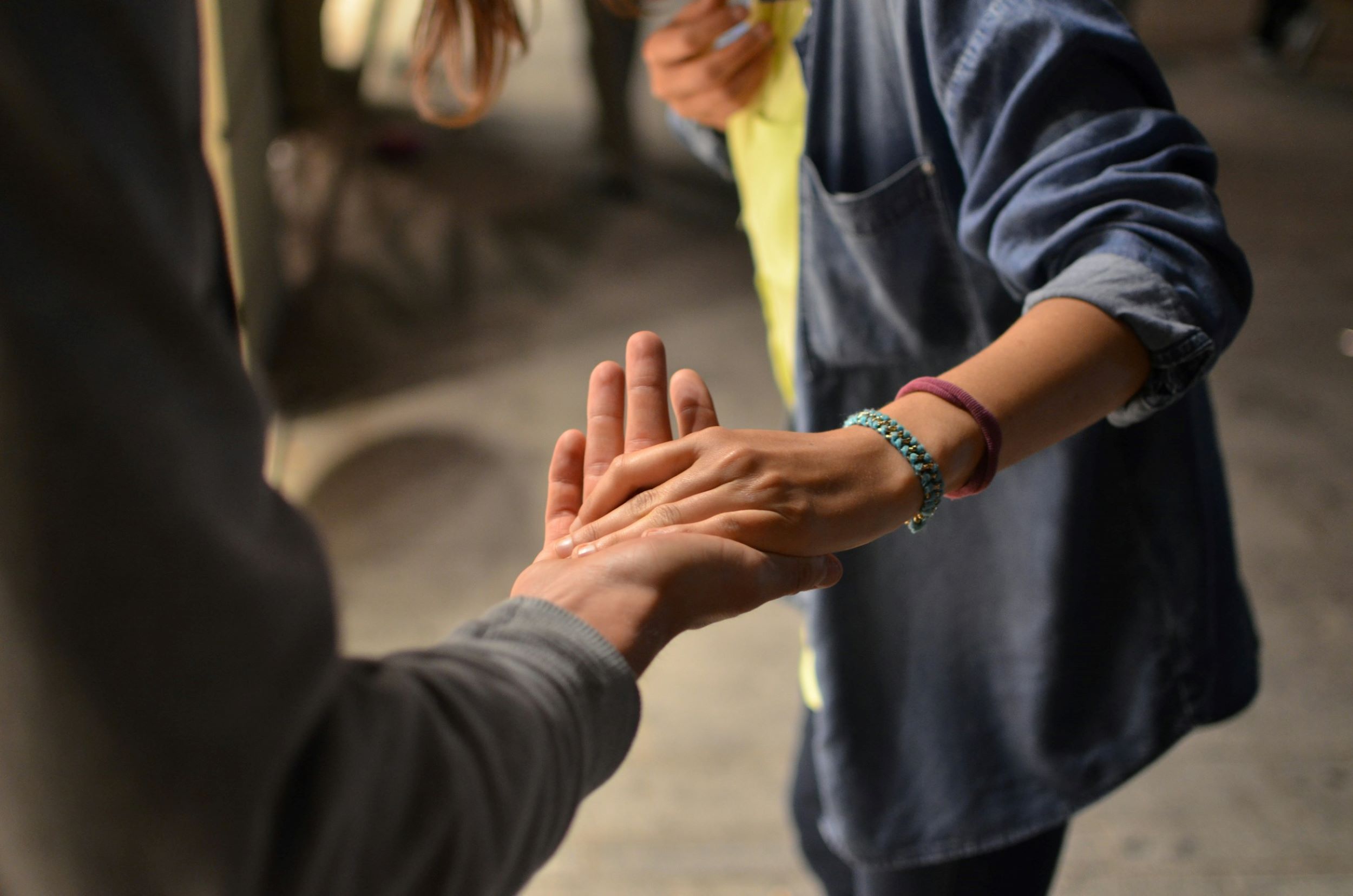 A woman guides an elderly woman with her hand.