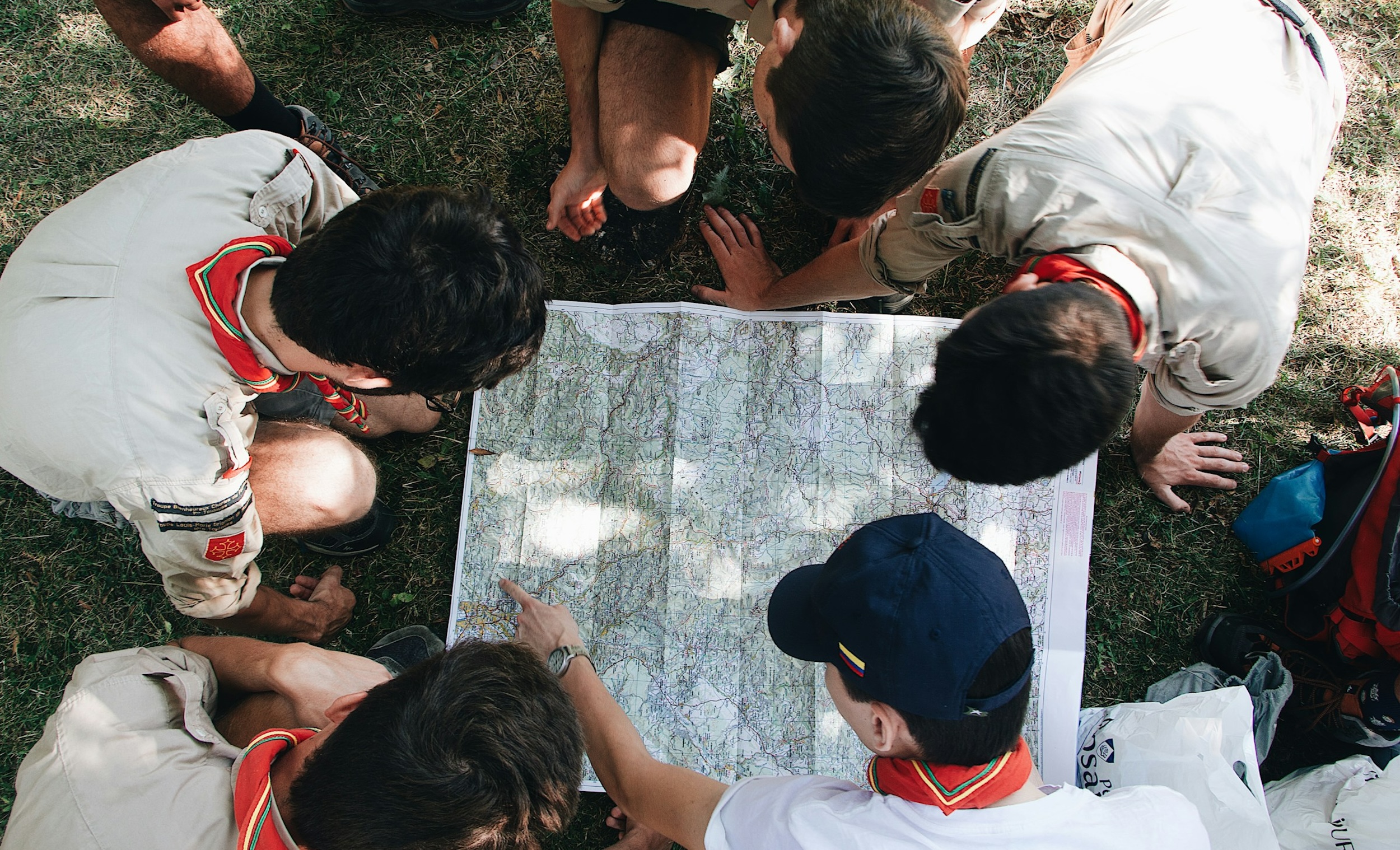 A group of boy scouts sit near a map.