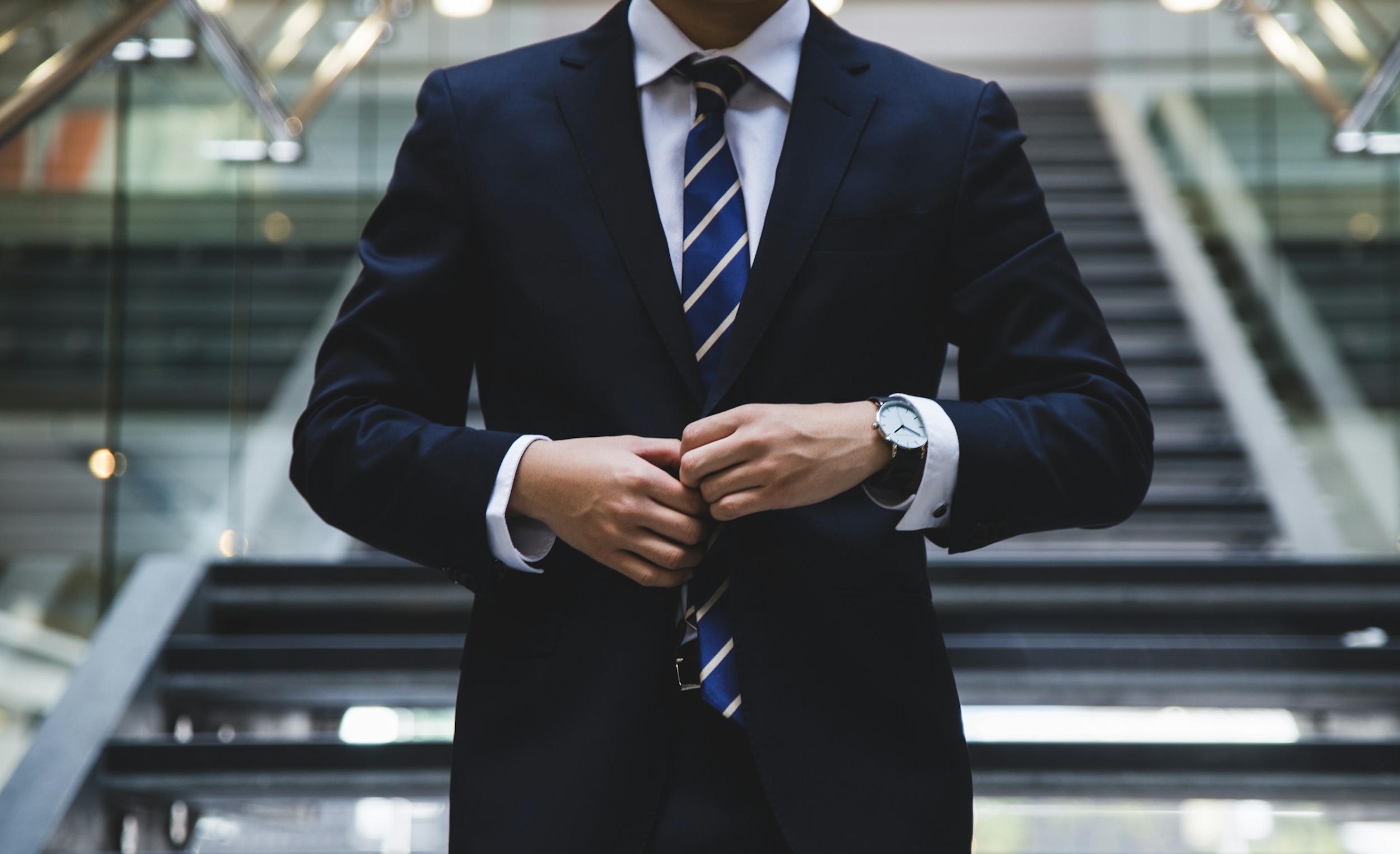 A man adjusts his business suit.