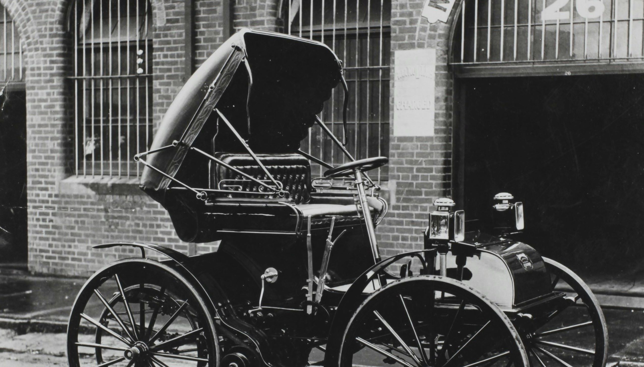 An empty carriage is positioned in front of a factory.