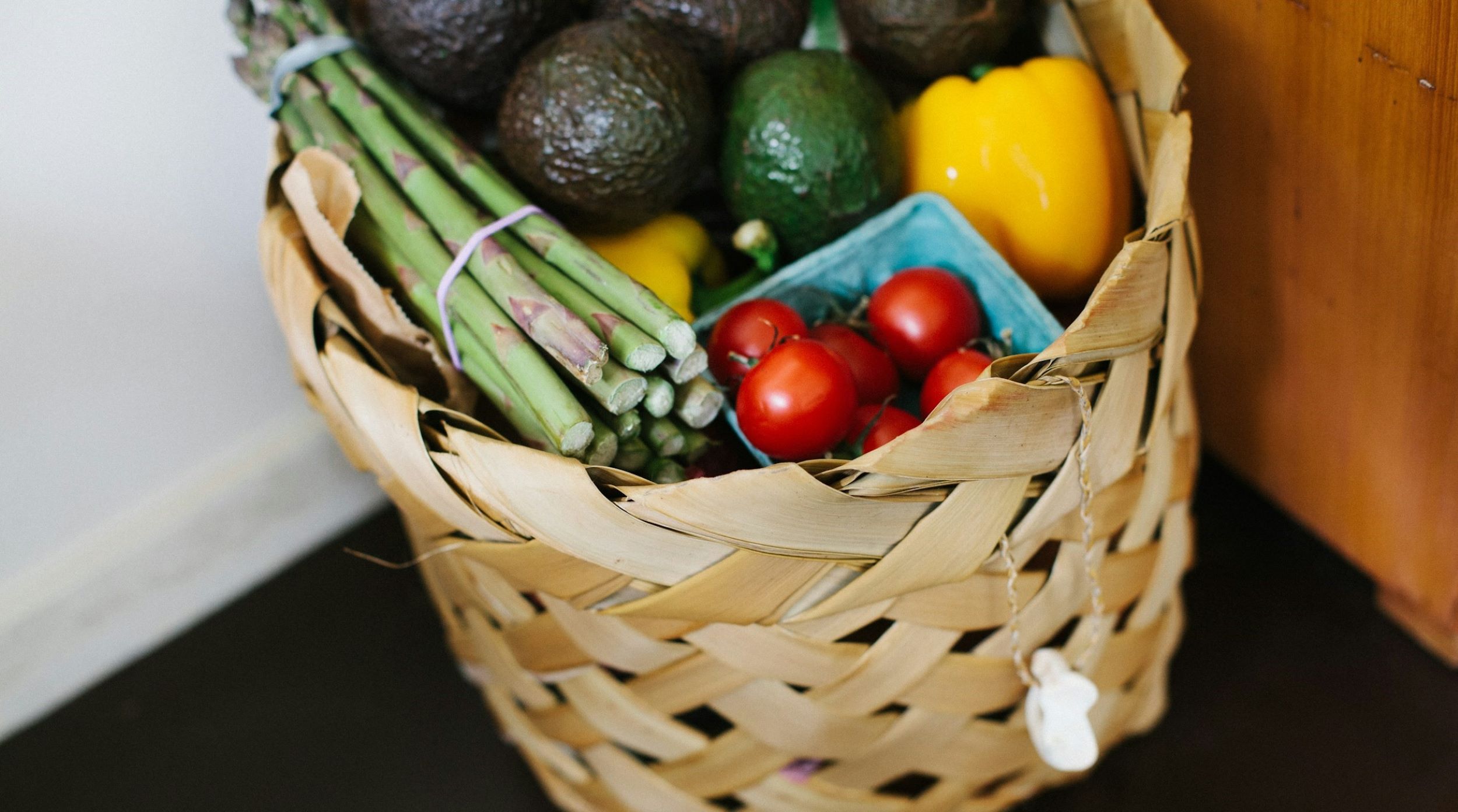 Vegetables are placed in a large woven basket.