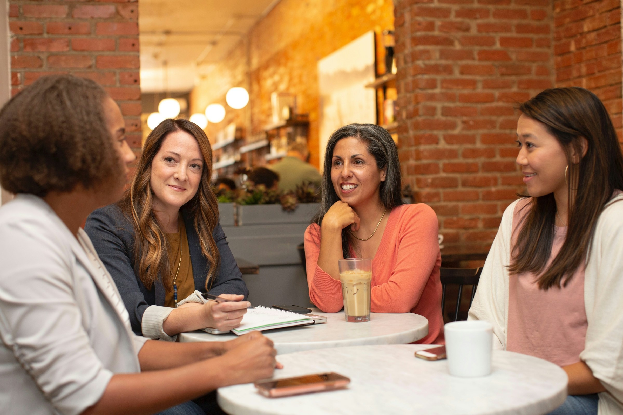 Four women sit in a room and have an engaging conversation.