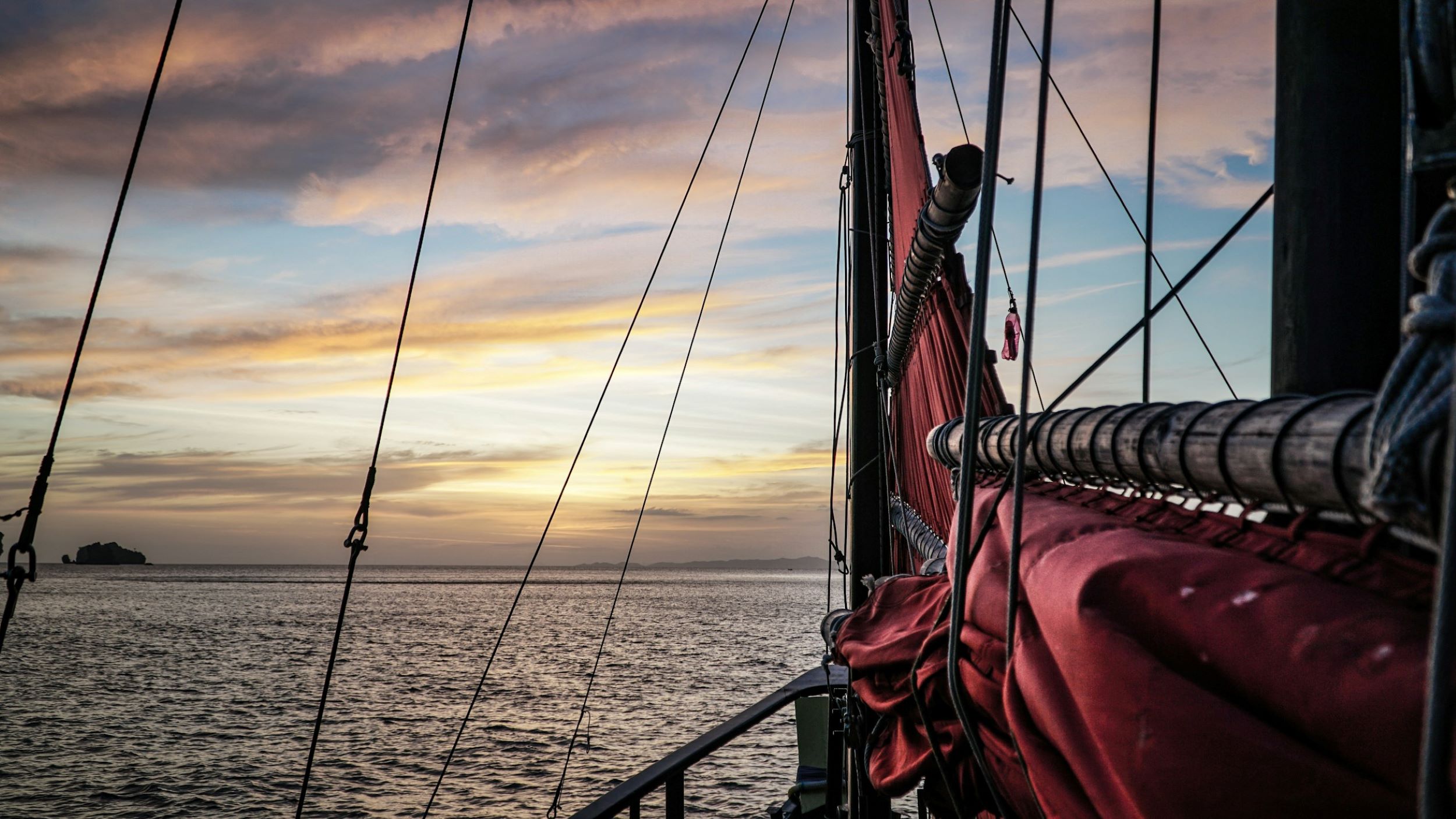 A pirate ship sails toward the horizon. 