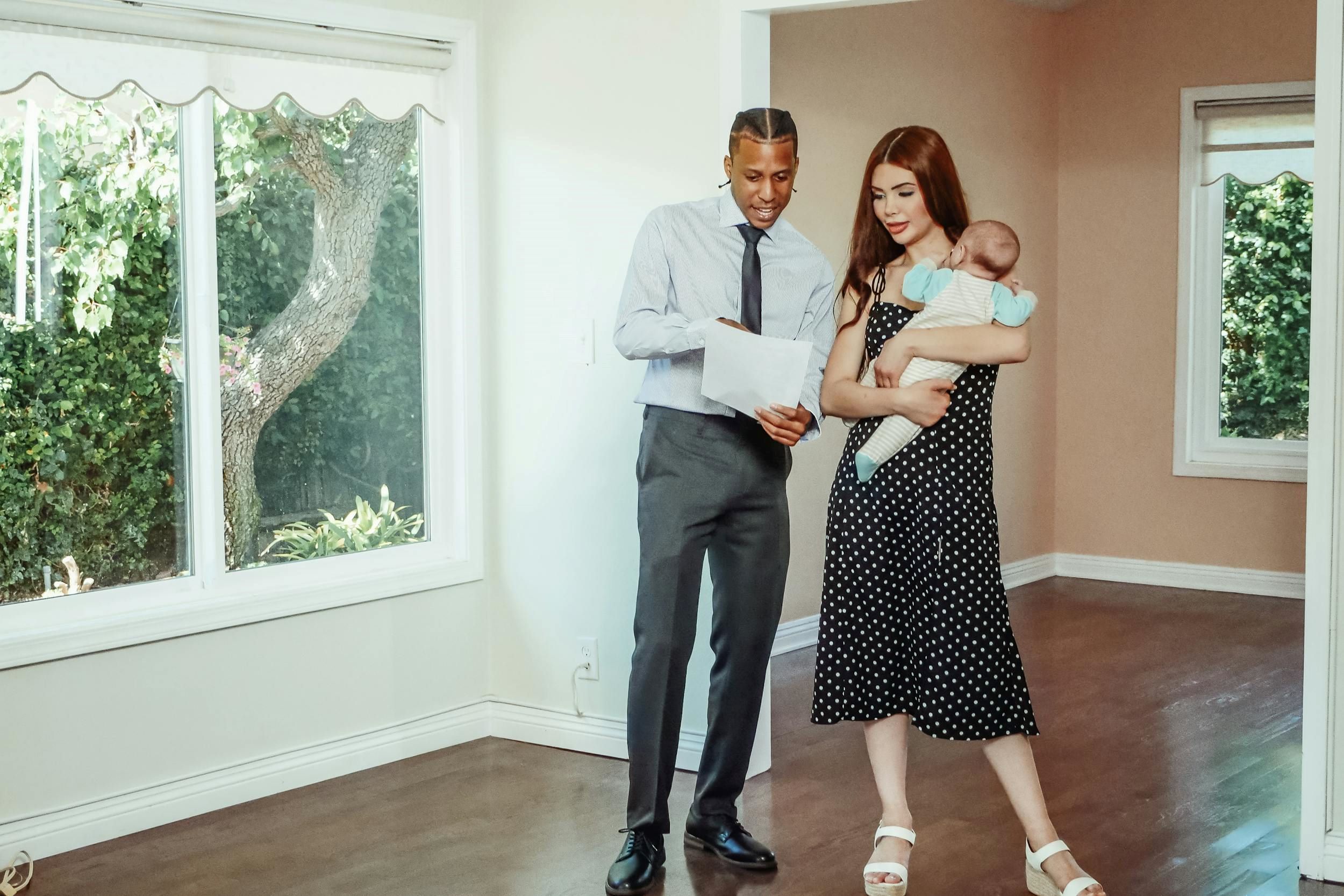 An agent speaks with a woman holding her baby.