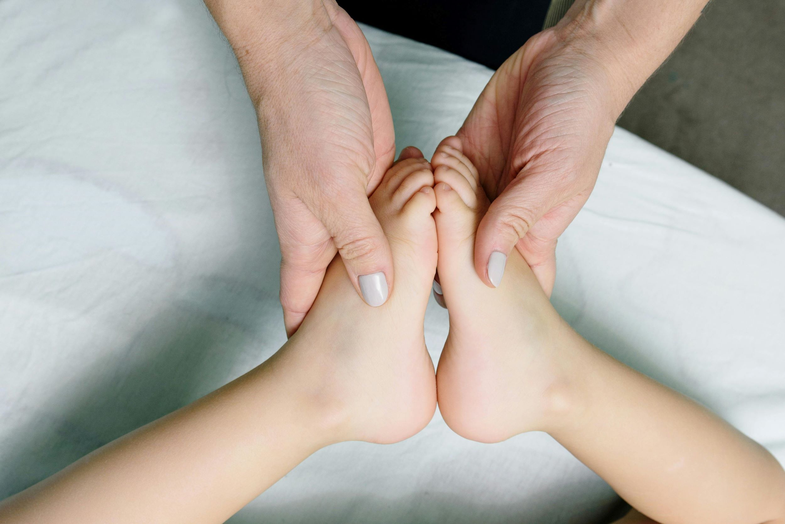 A therapist positions a young patient’s feet together.