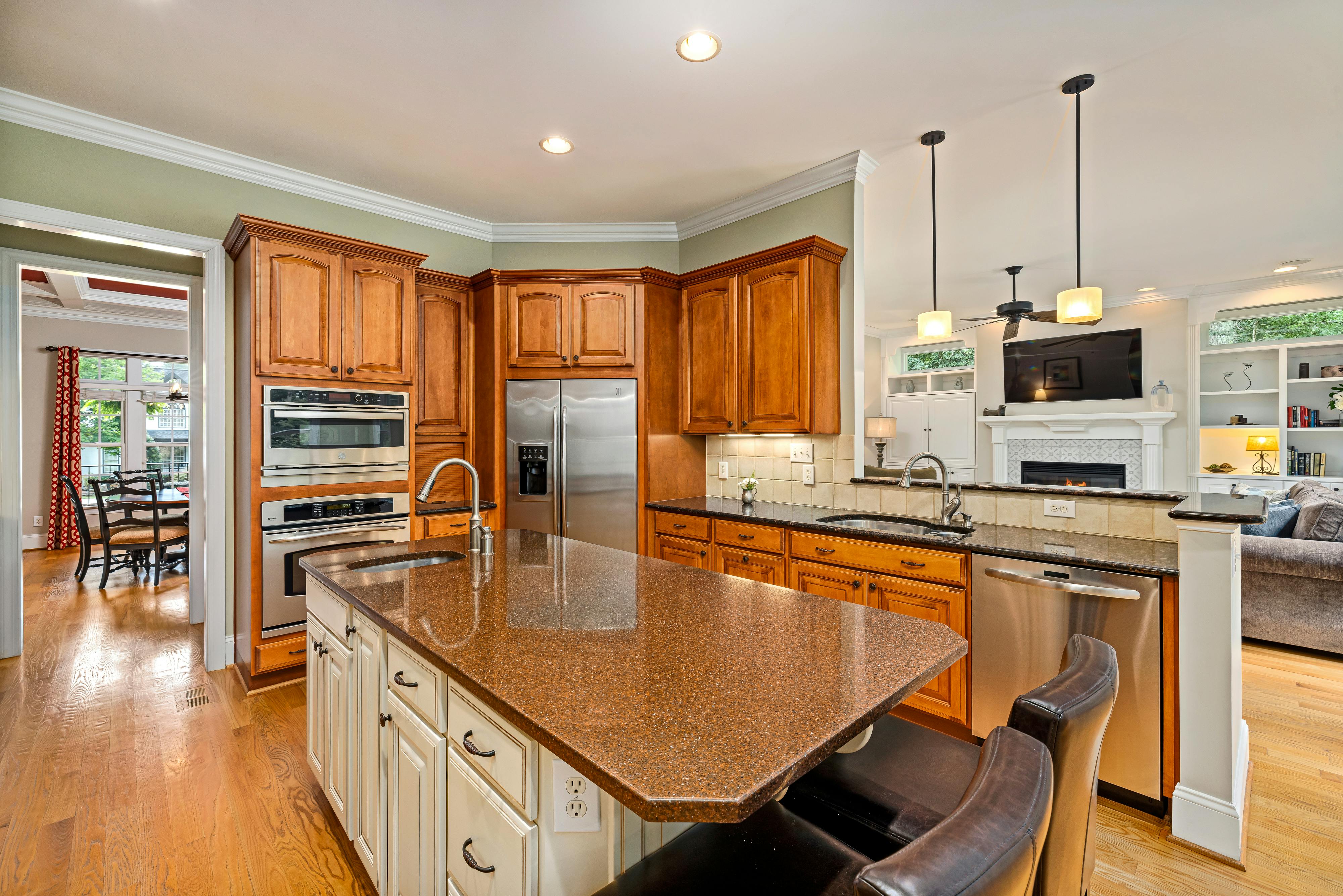 An interior view of a kitchen that includes a dining area and features warm wooden accents.