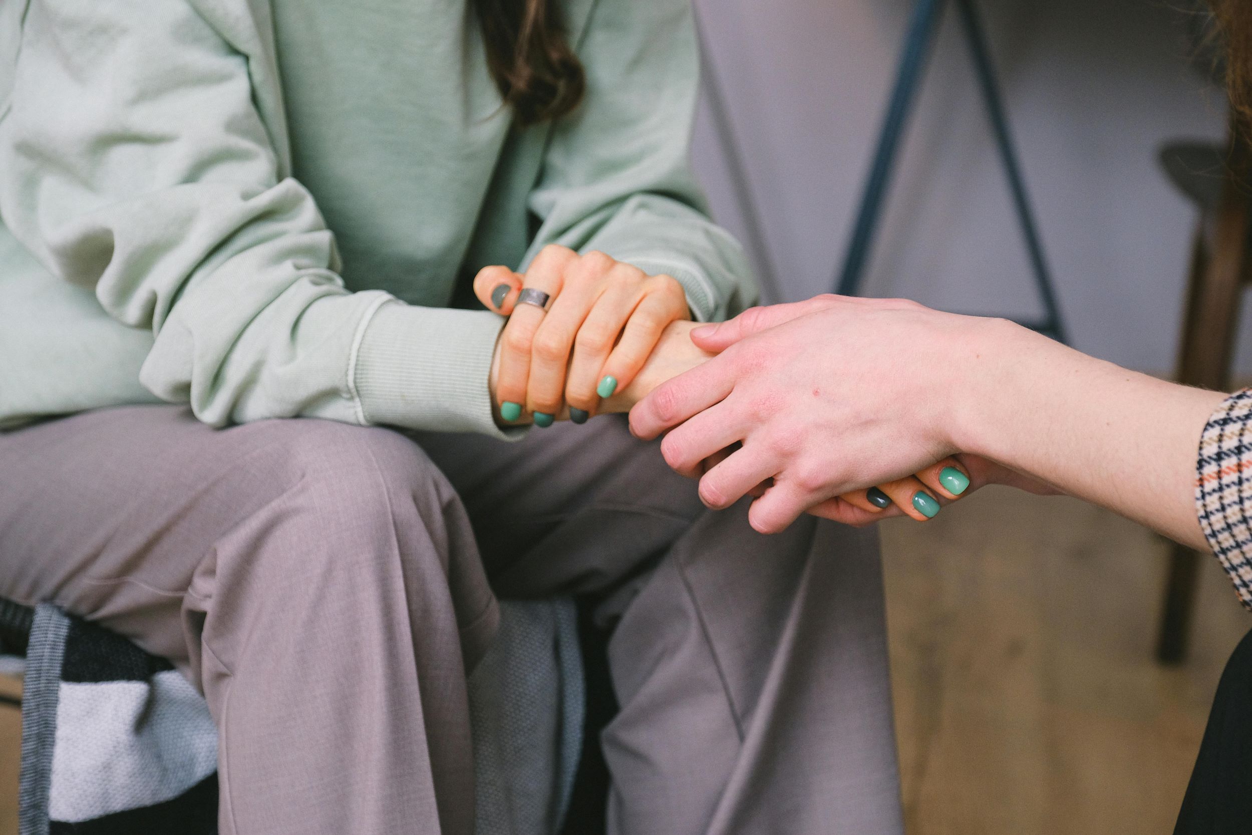 A therapist expresses empathy by holding her patient's hand.