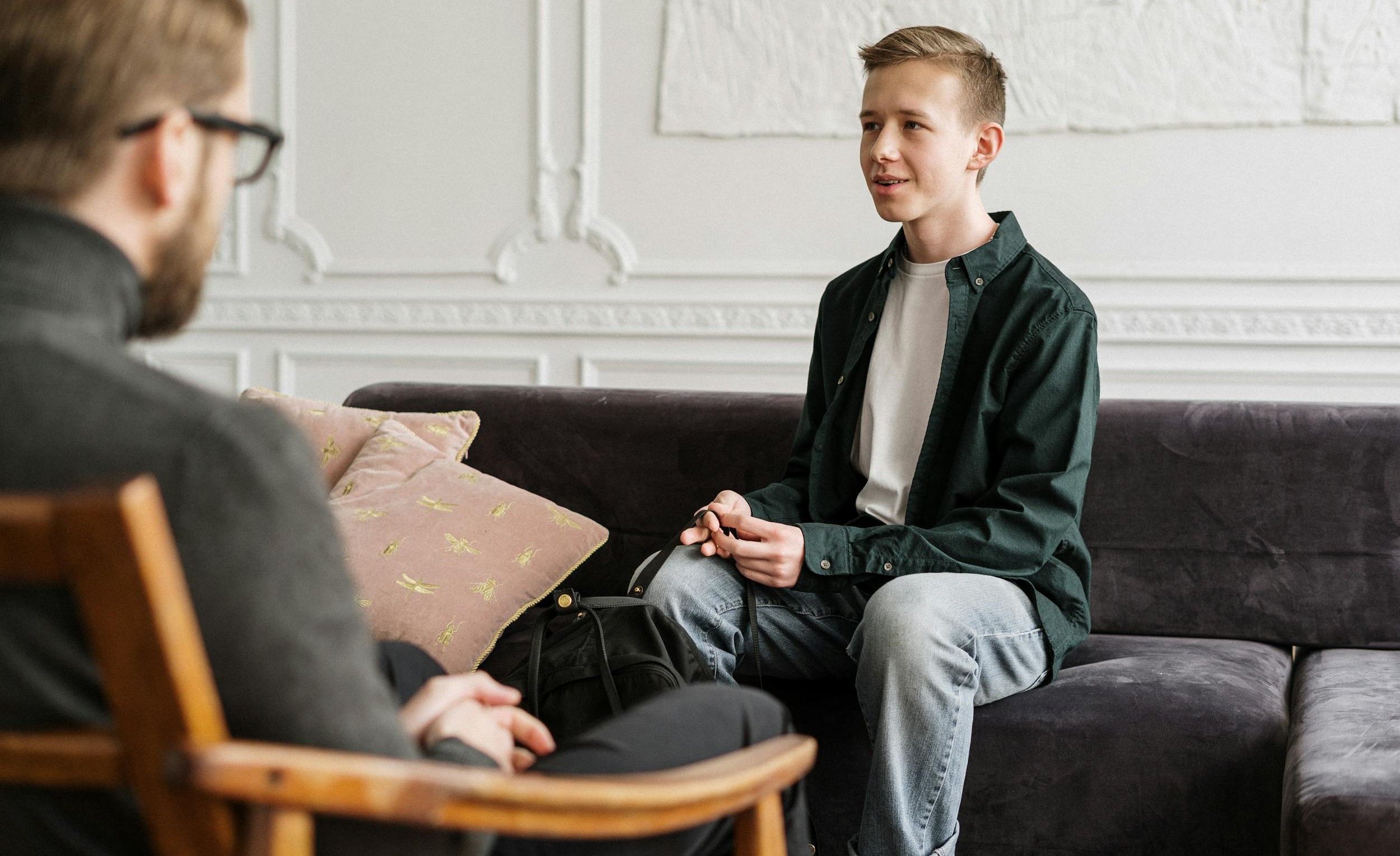 A therapist meets with a young man.