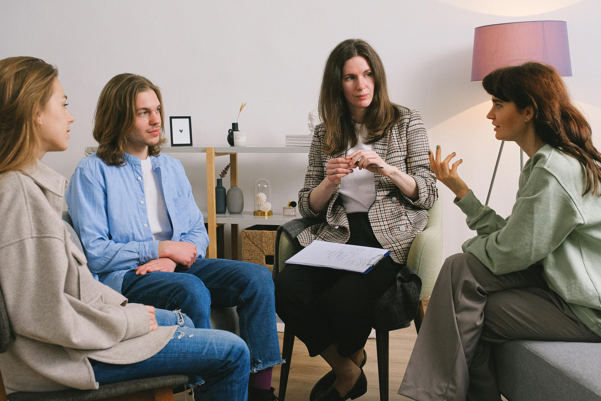 A therapist conducts a group session with her clients.