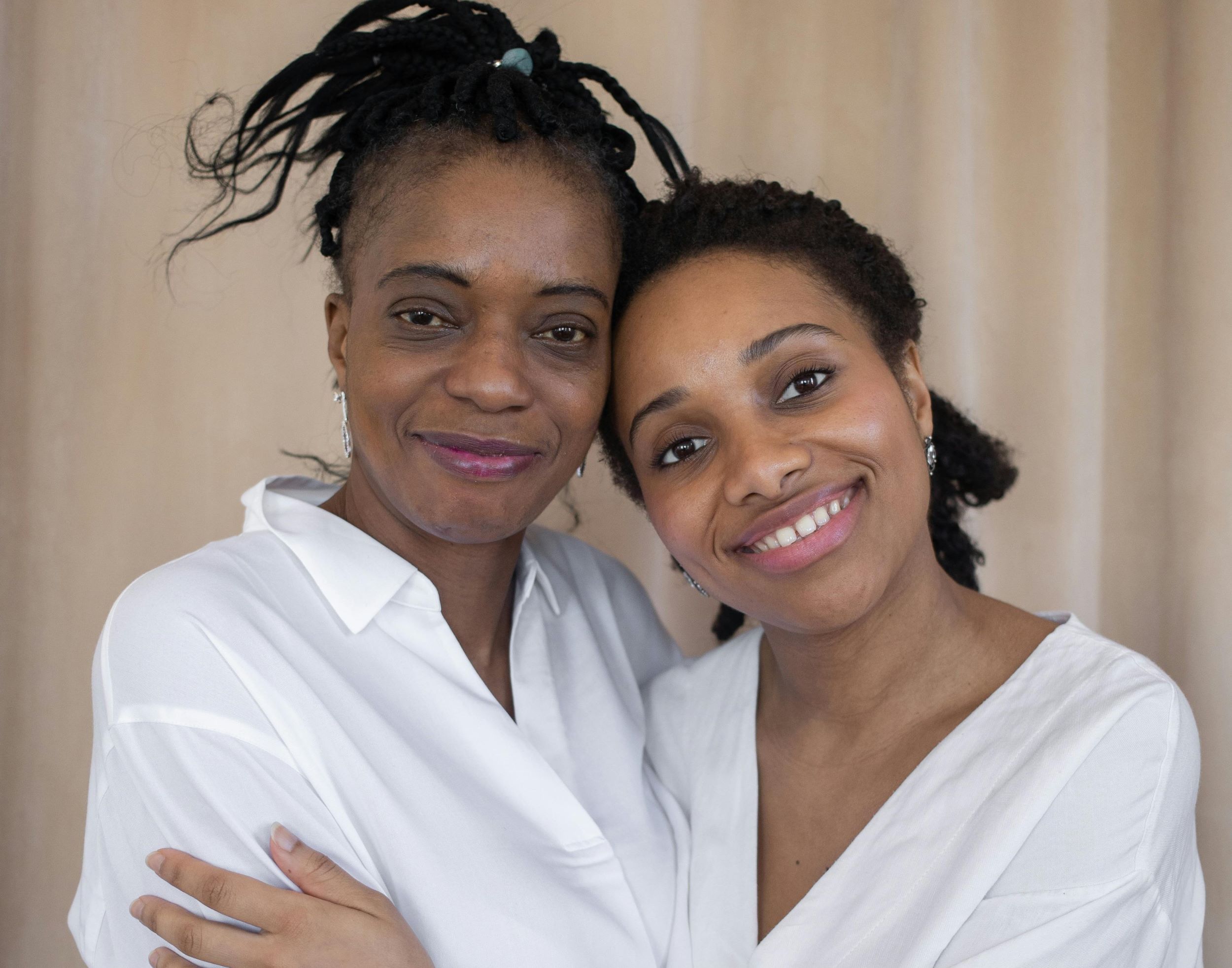 Two women smile while embracing each other.