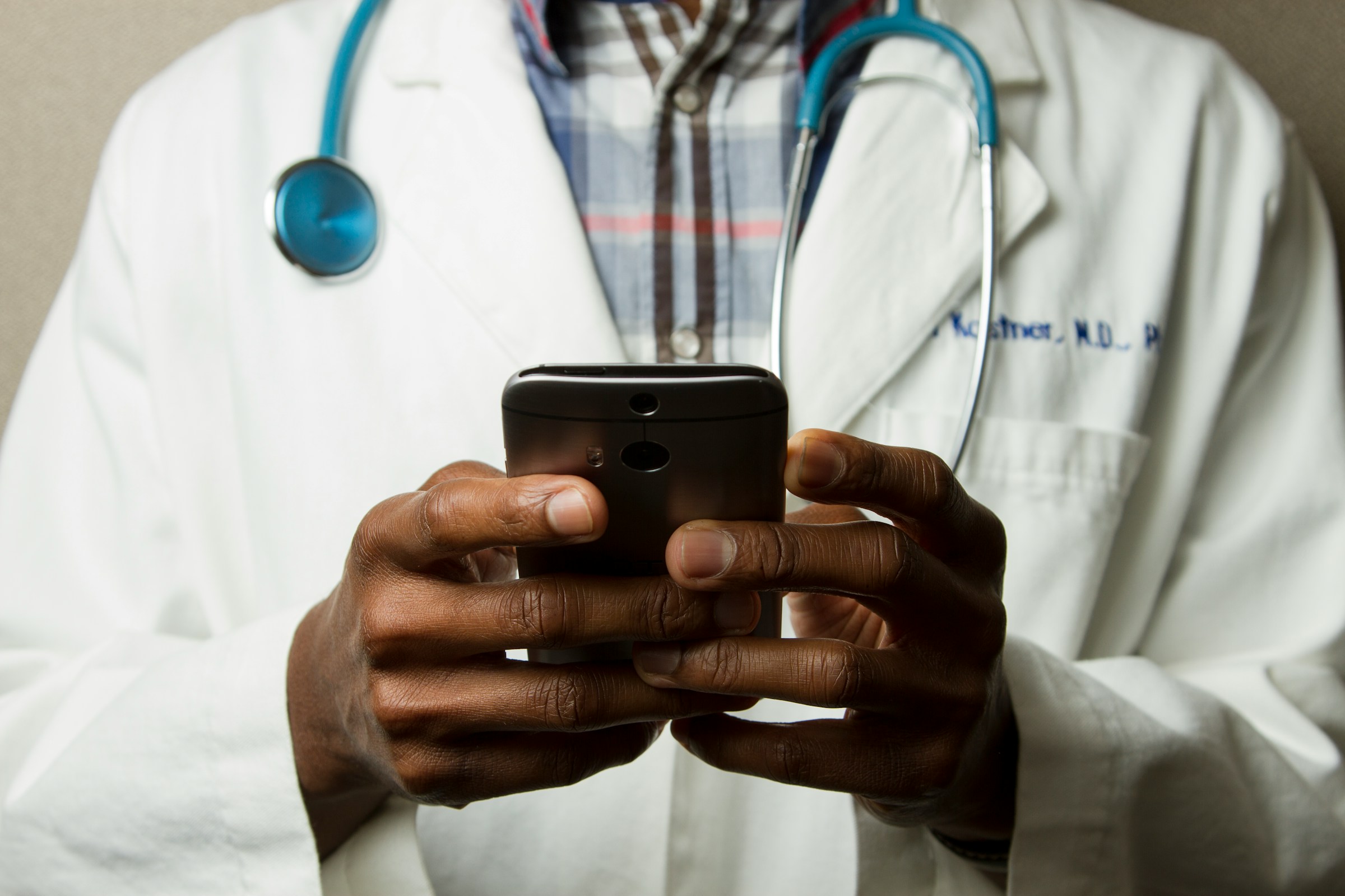 A doctor taps on icons on his cellphone.