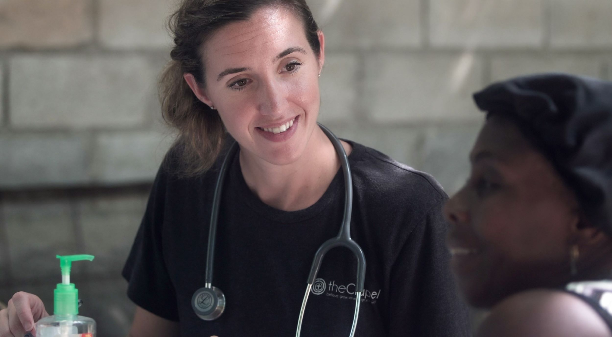 A nurse smiles and speaks with a patient.