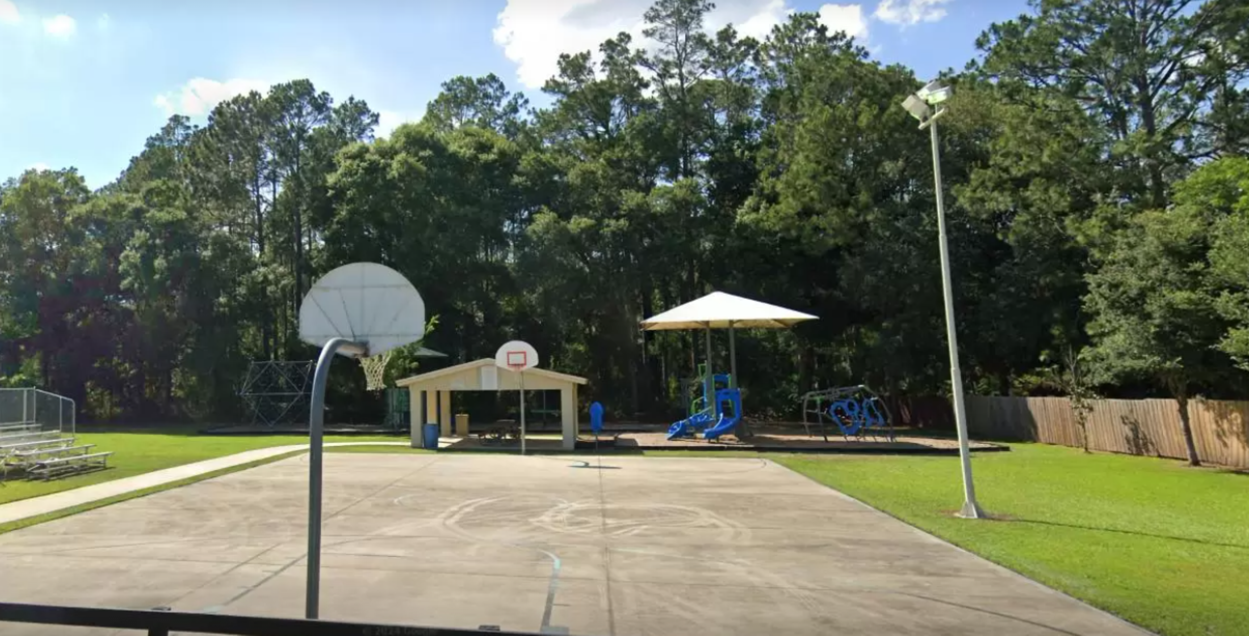 The basketball court remains empty on a sunny day.