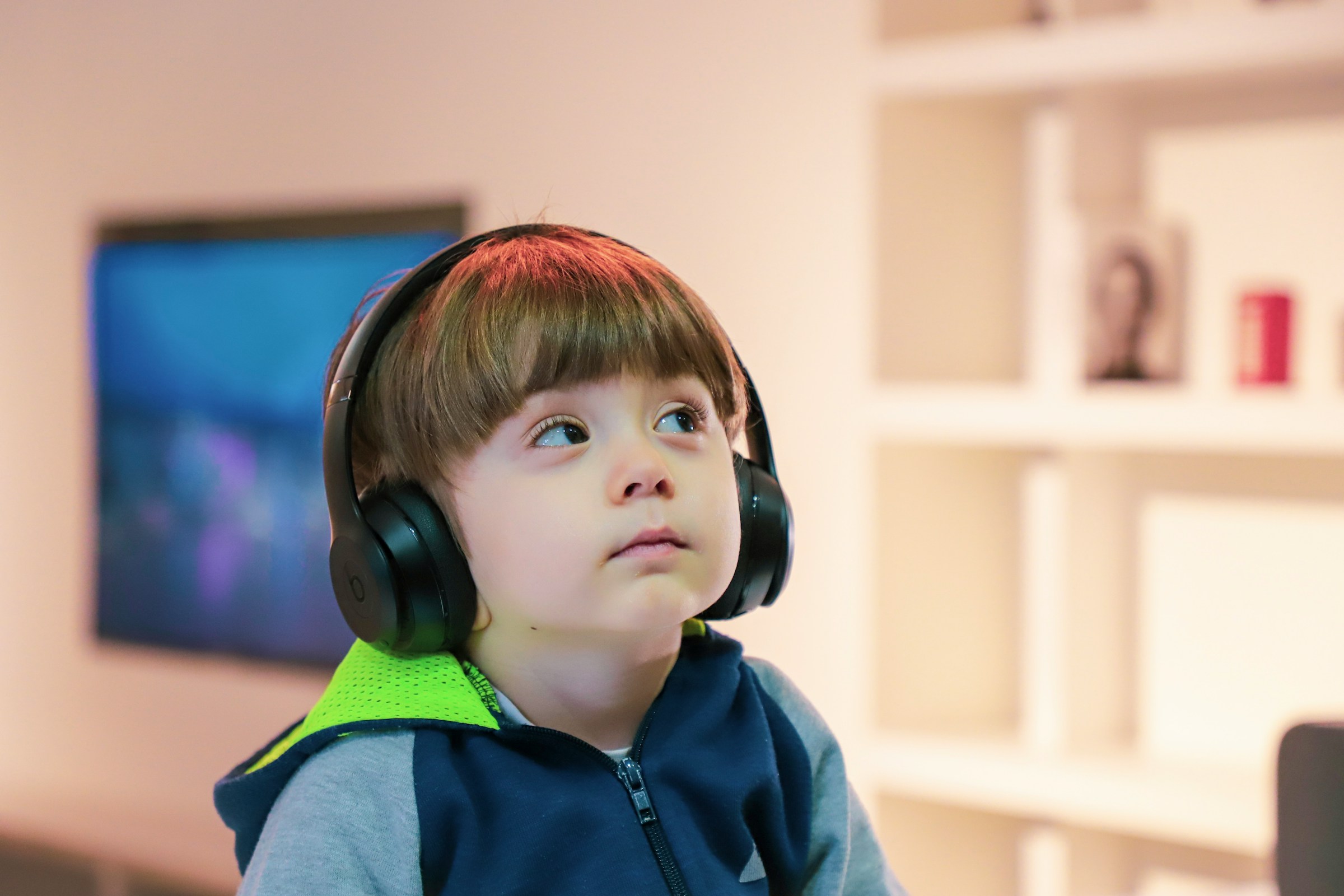 A child with autism wears headphones and stares at an object in the distance.