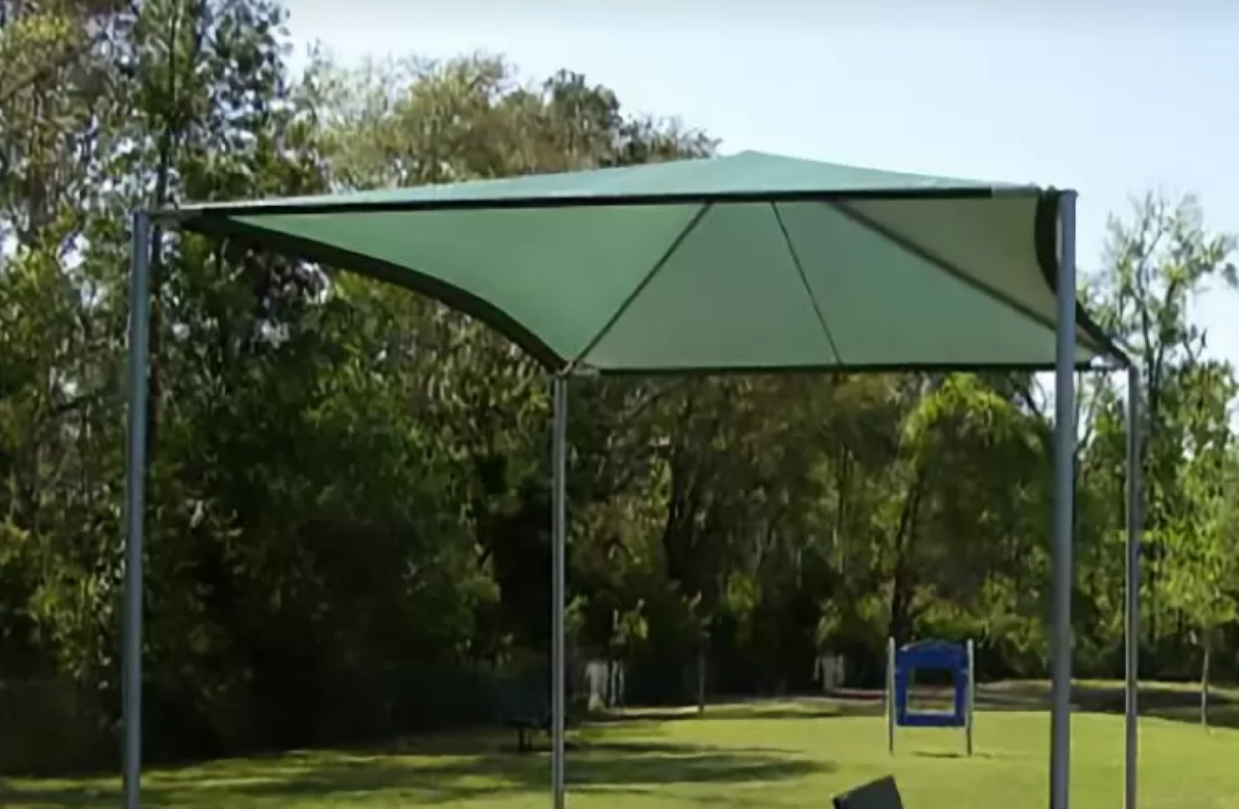 A large canopy stands tall at Davis Park, providing shade on a sunny day.