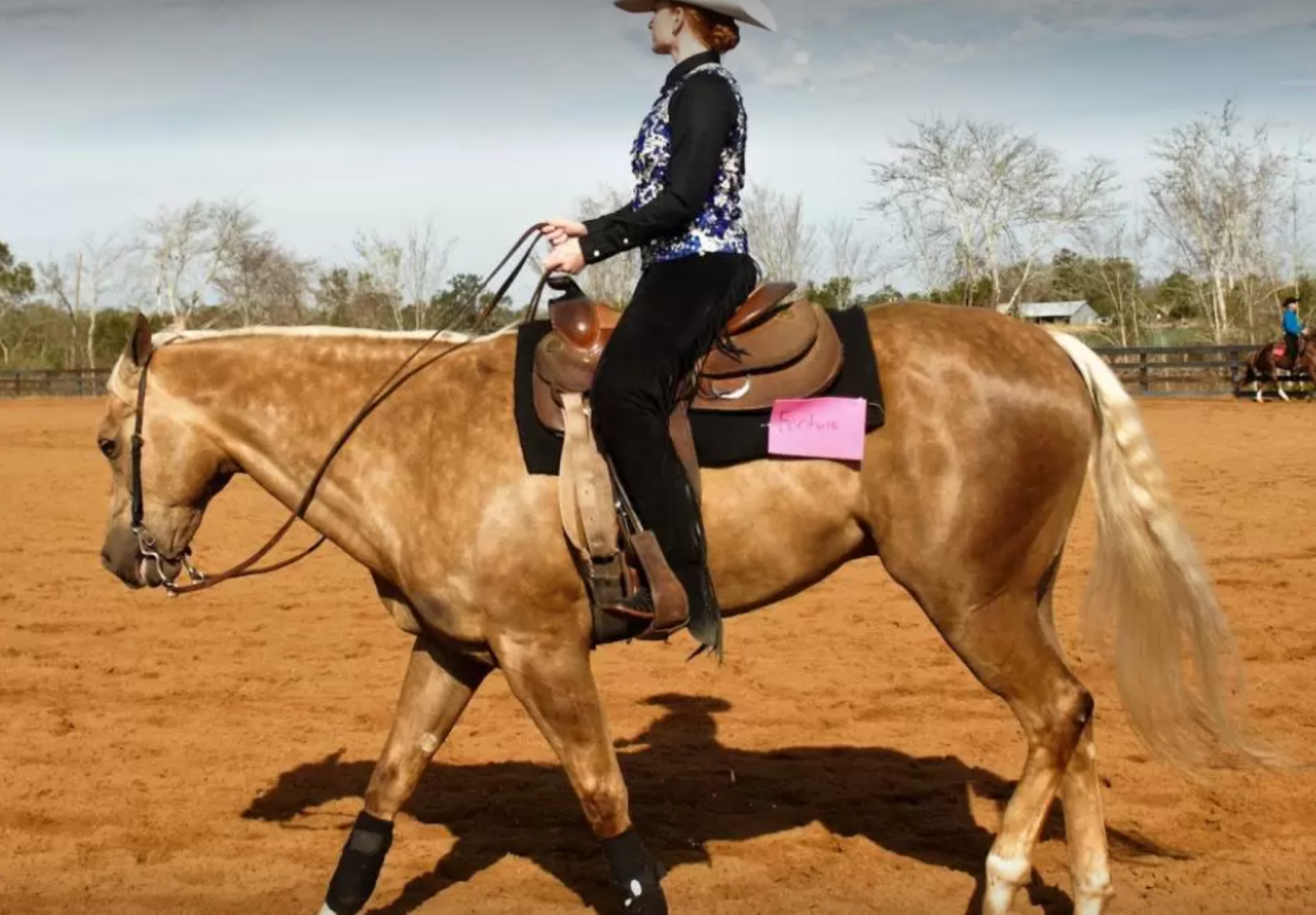 A woman rides a horse at the Equestrian Center.