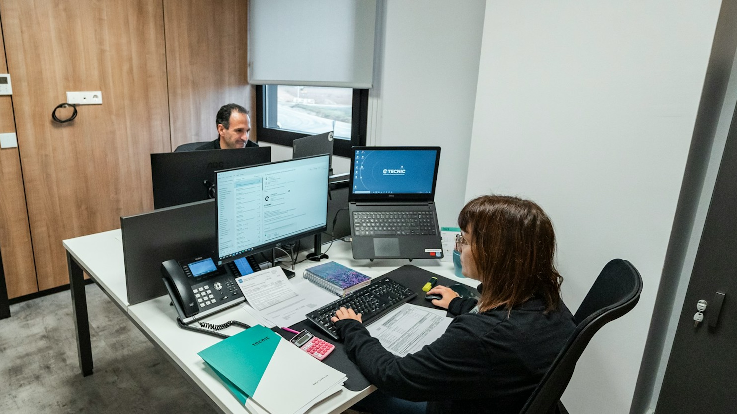 A man and woman work in an office.