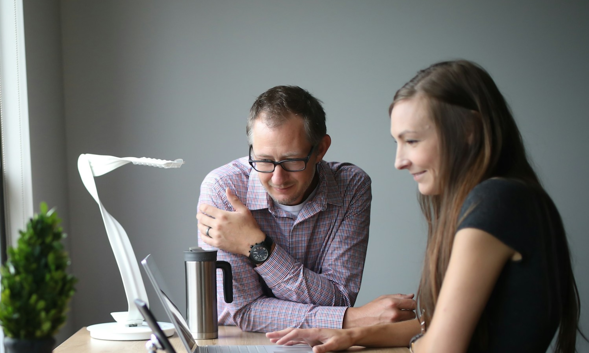 A man and woman speak in an office.
