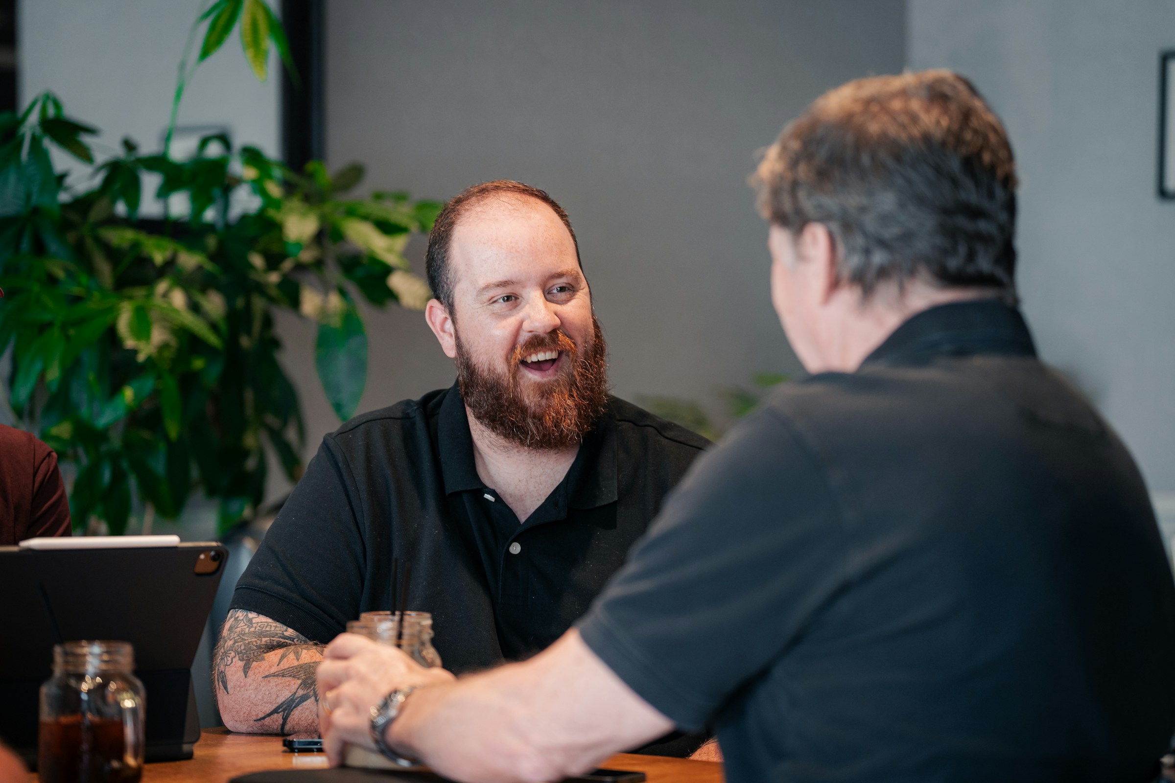 Two men smile and speak in a office.