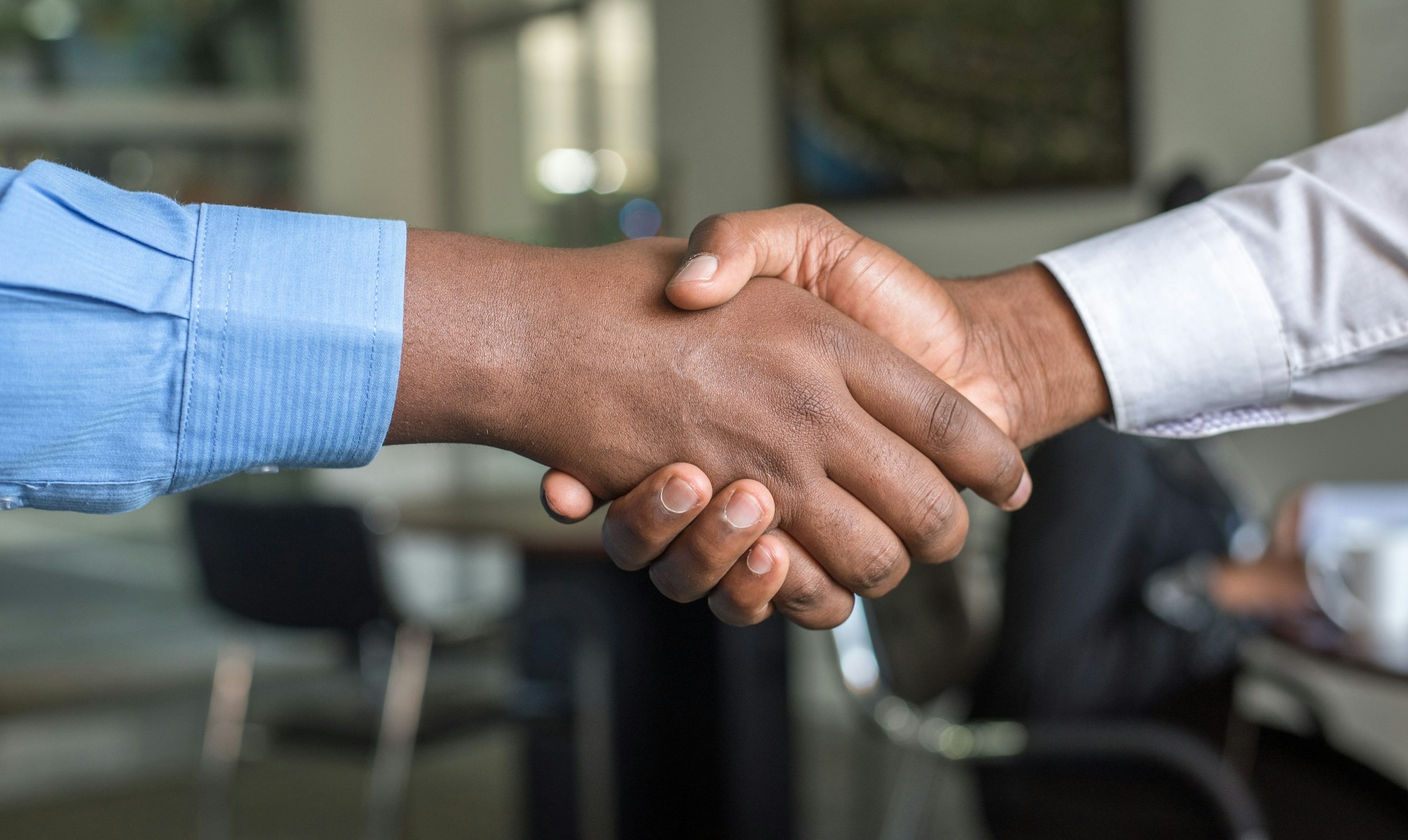 Two men shake hands in an office.