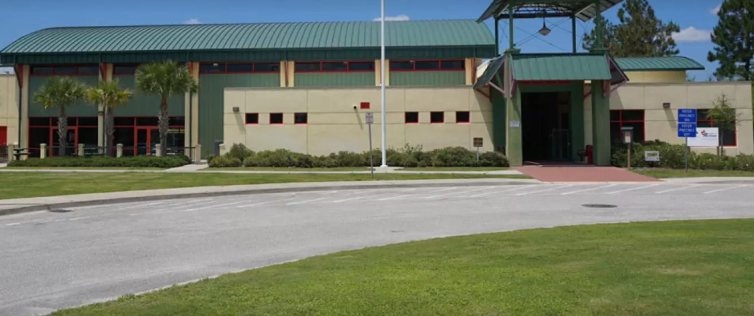 The Solomon Calhoun Community Center stands bright and welcoming under a clear, sunny sky.