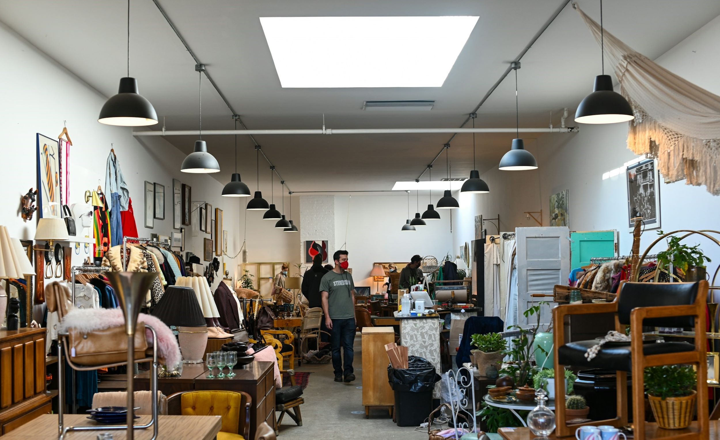 A man walks through a cozy thrift store.