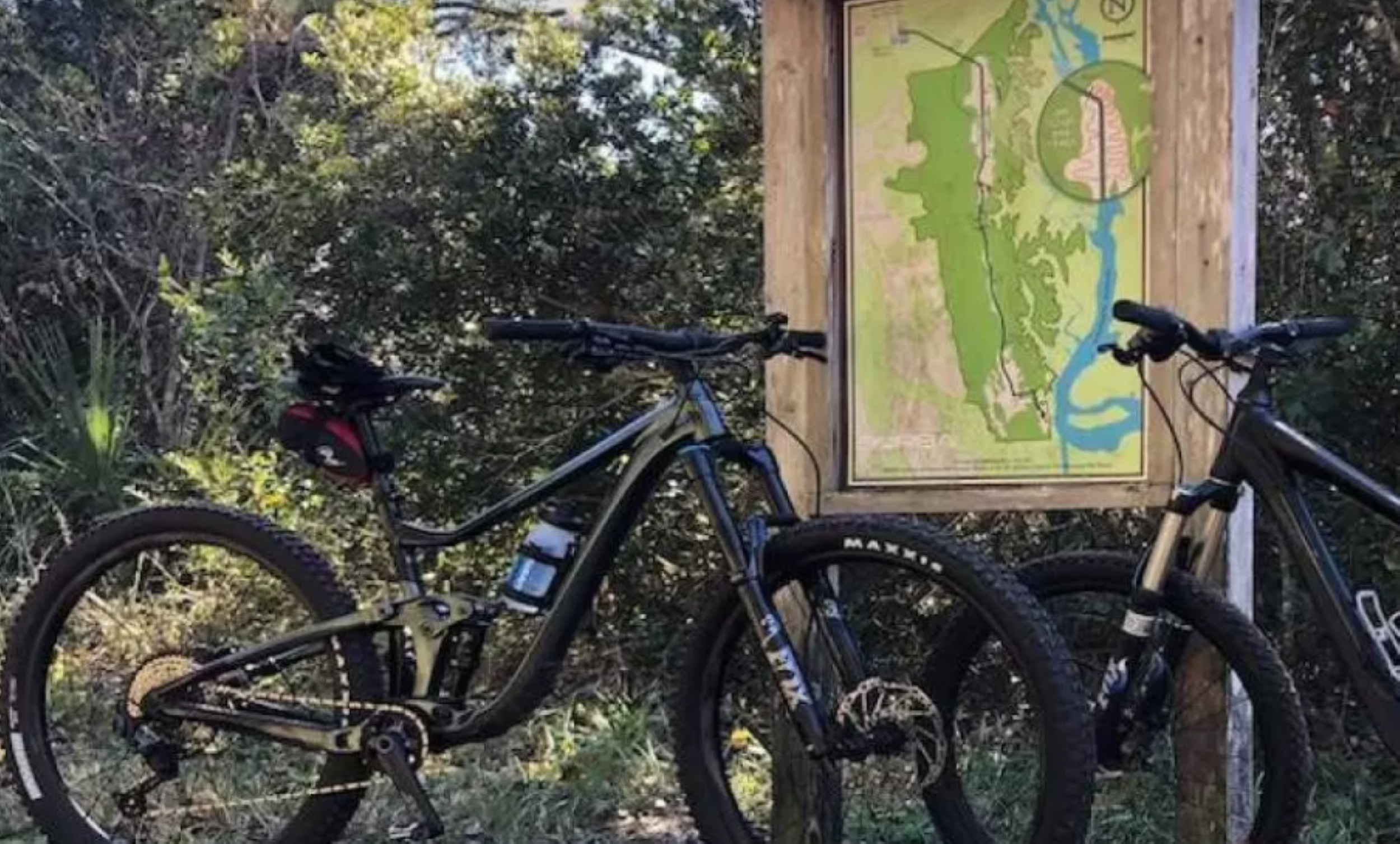 A bike is positioned in front of a sign at the Nocatee Preserve.