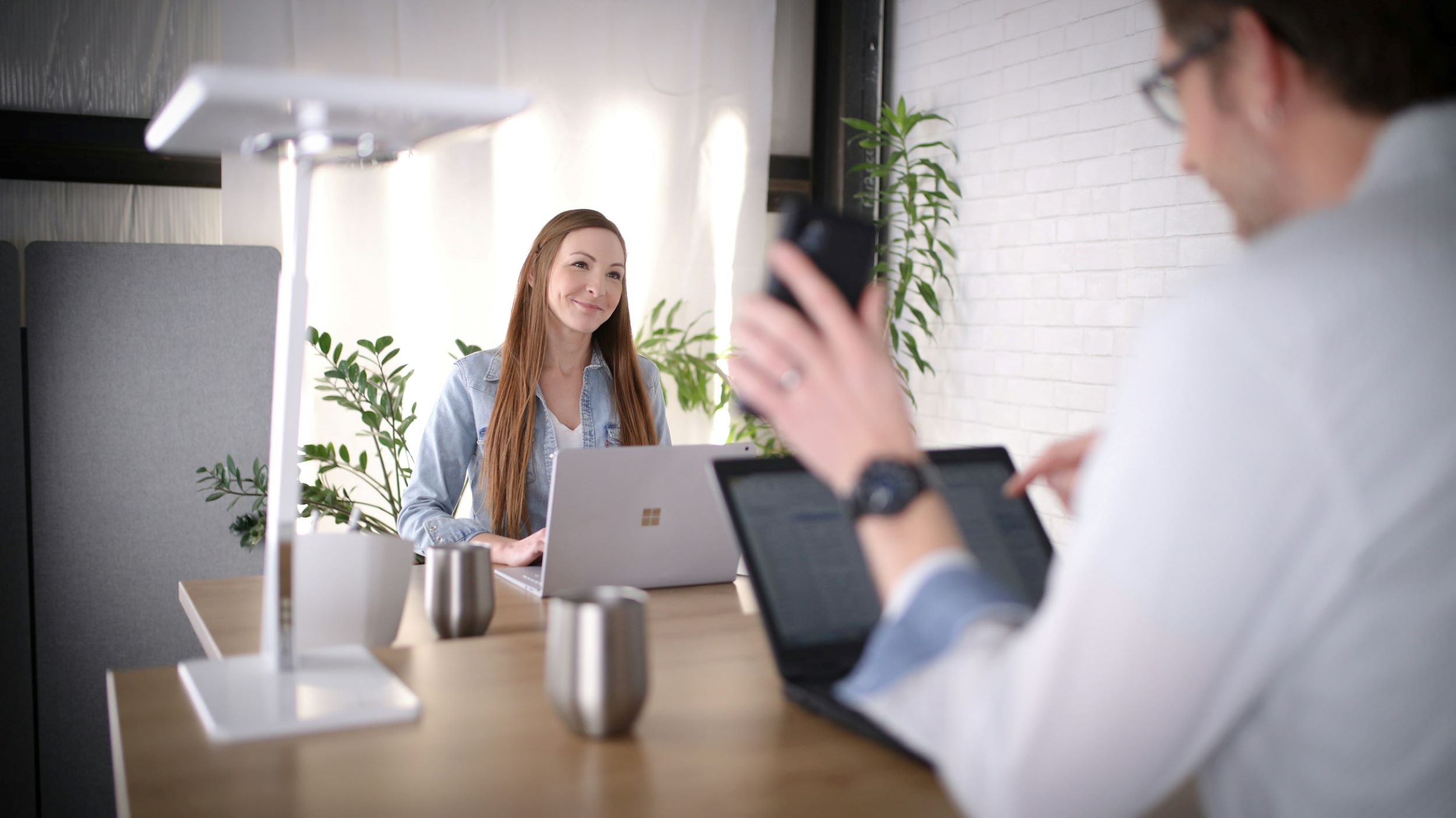 A man and a woman speak in an office.