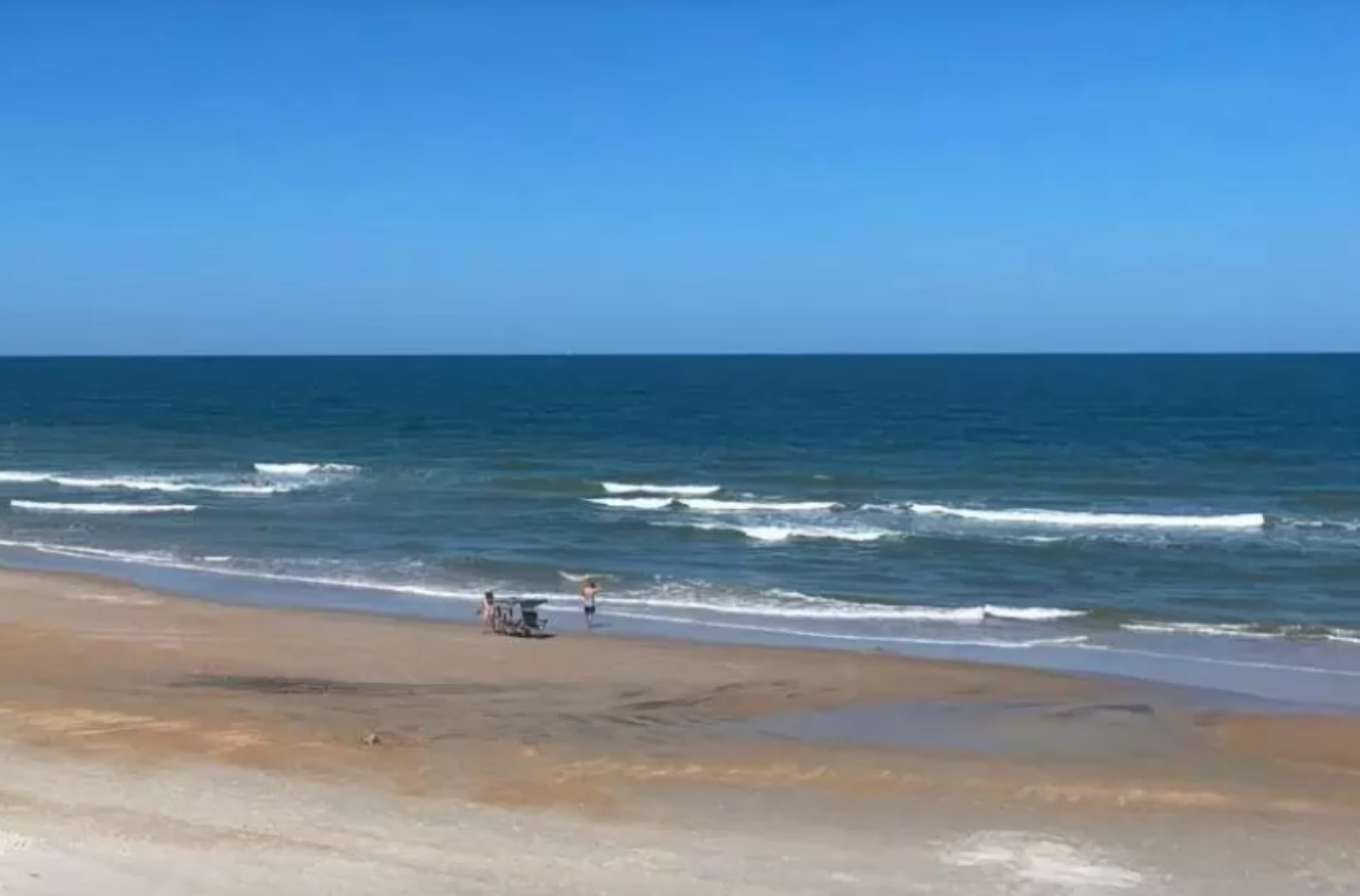 Waves drift gently away from a shore.