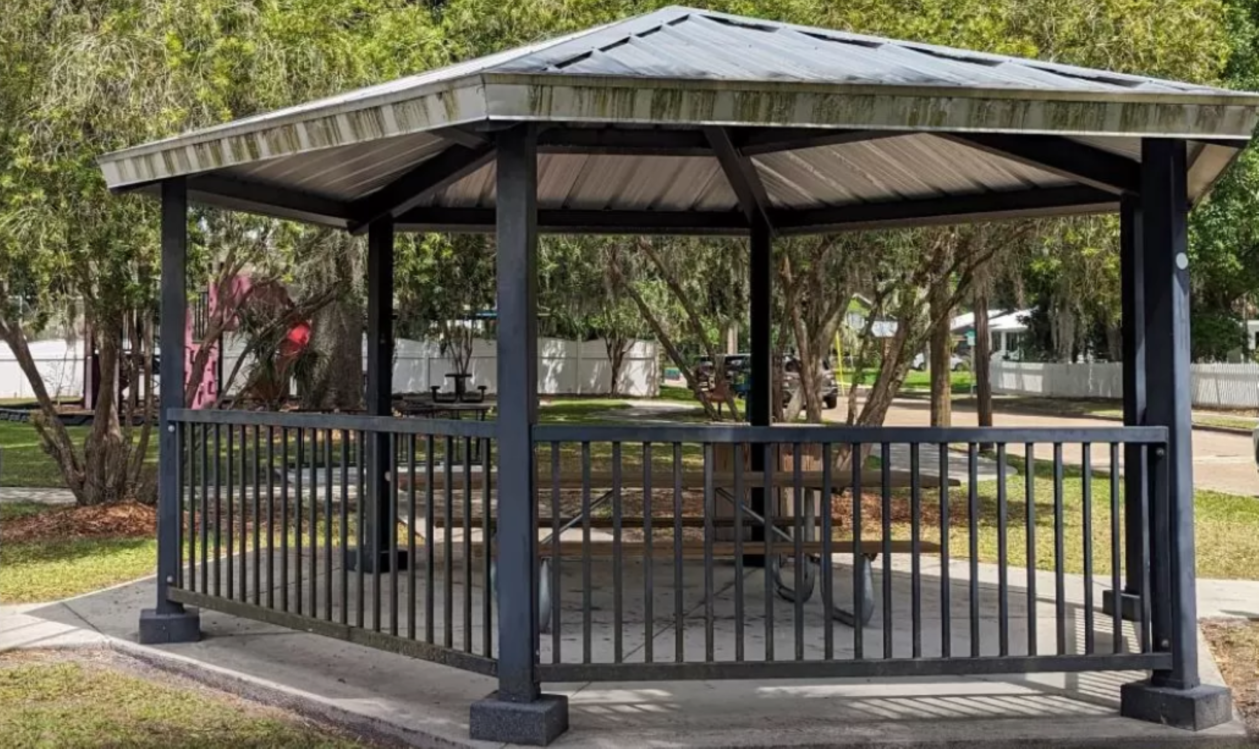 An empty pavilion in Railroad Park is furnished with benches and tables.