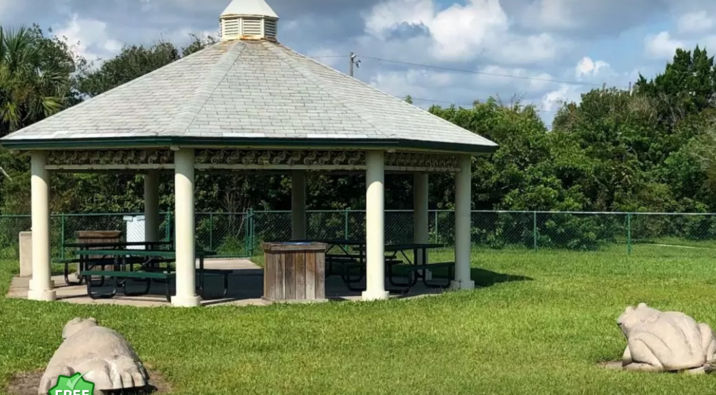A pavilion equipped with benches remains empty on a summer day.