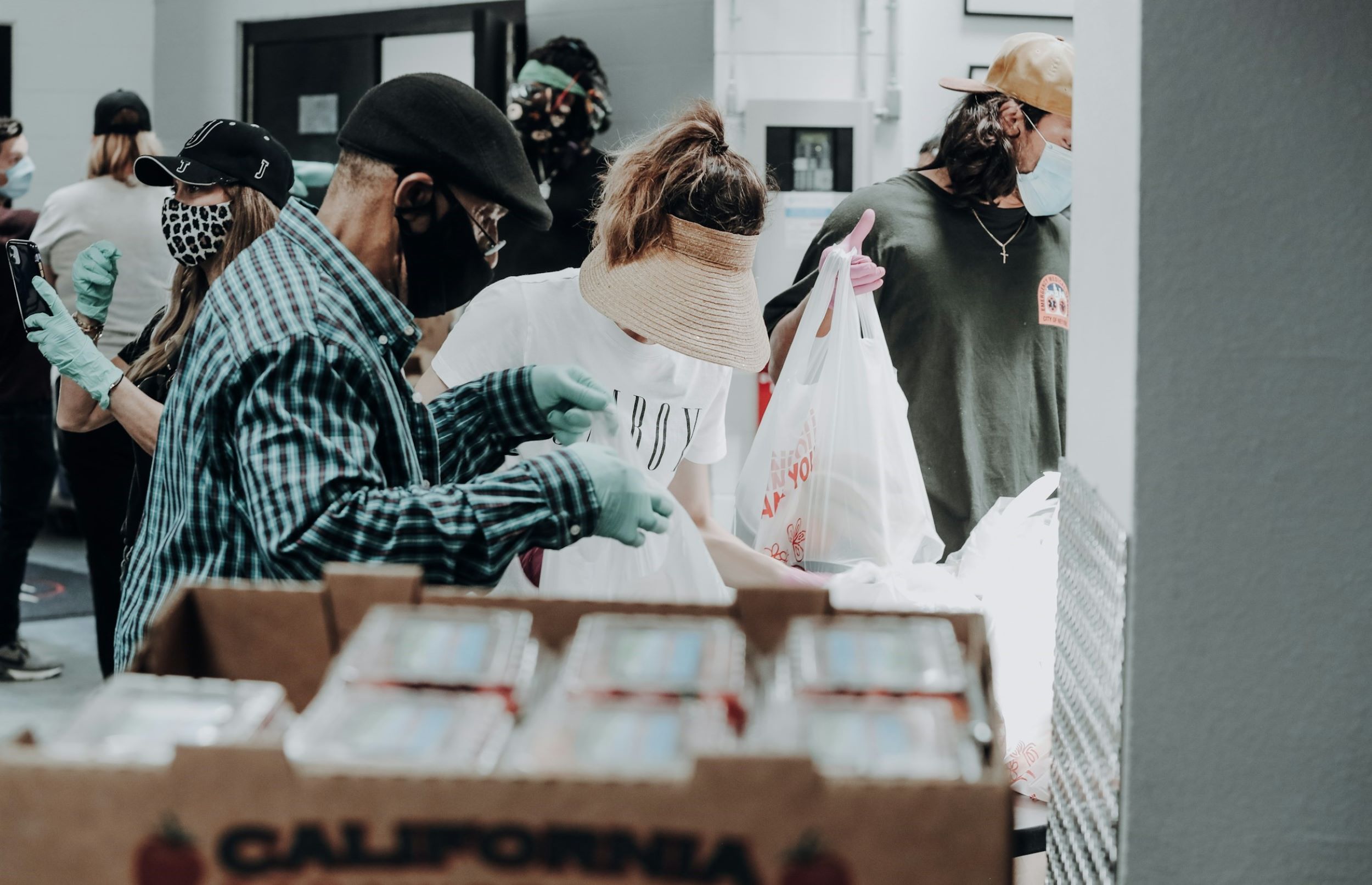 A team of masked volunteers holds bags ready for delivery to people in need.