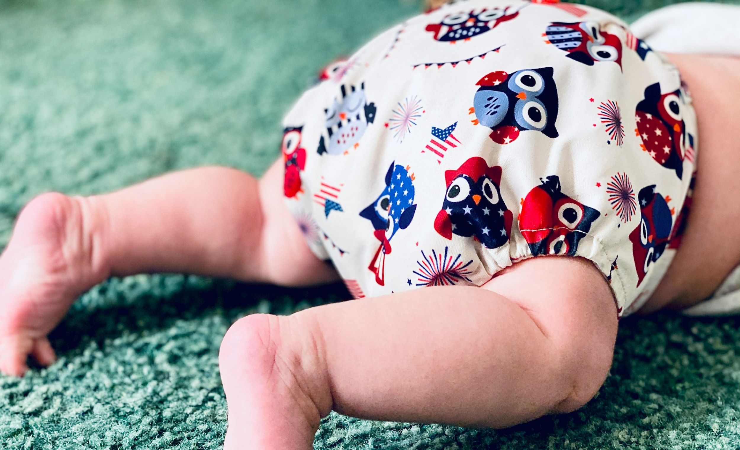 A baby crawls in his diaper.