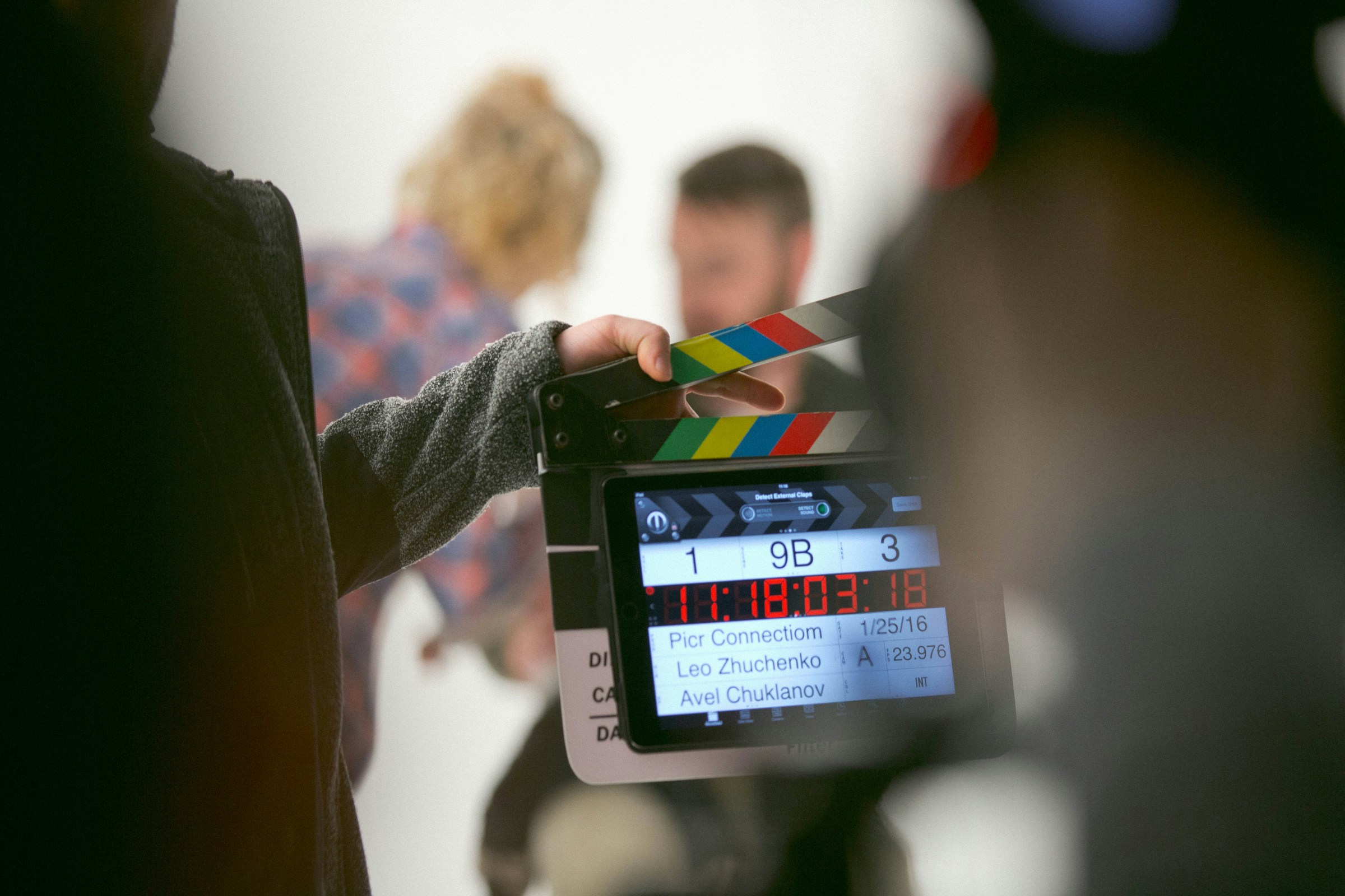 A man clutches a clapperboard on a film set.