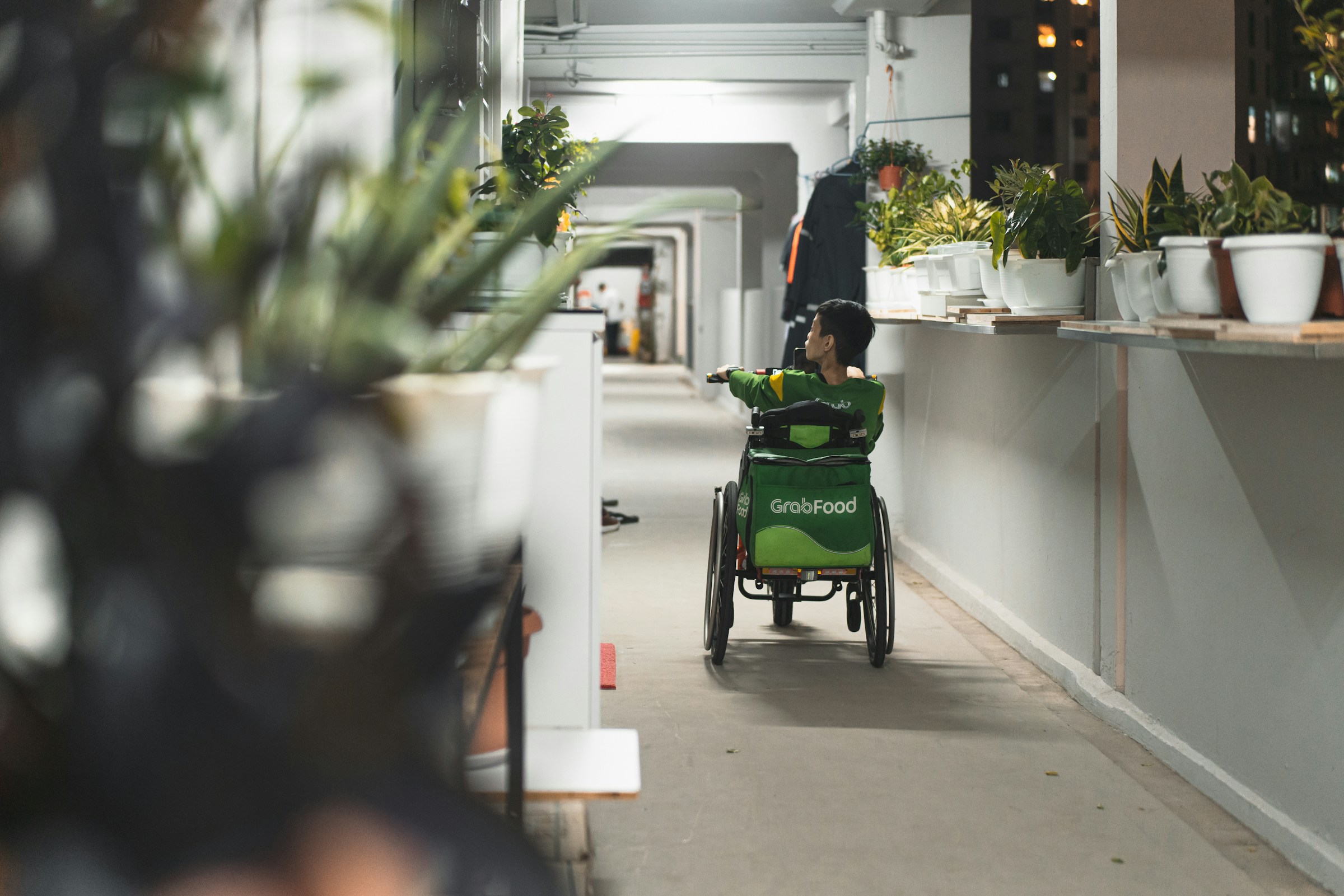 A child with an exceptional need sits in his wheelchair and waits at a receptionist’s desk.