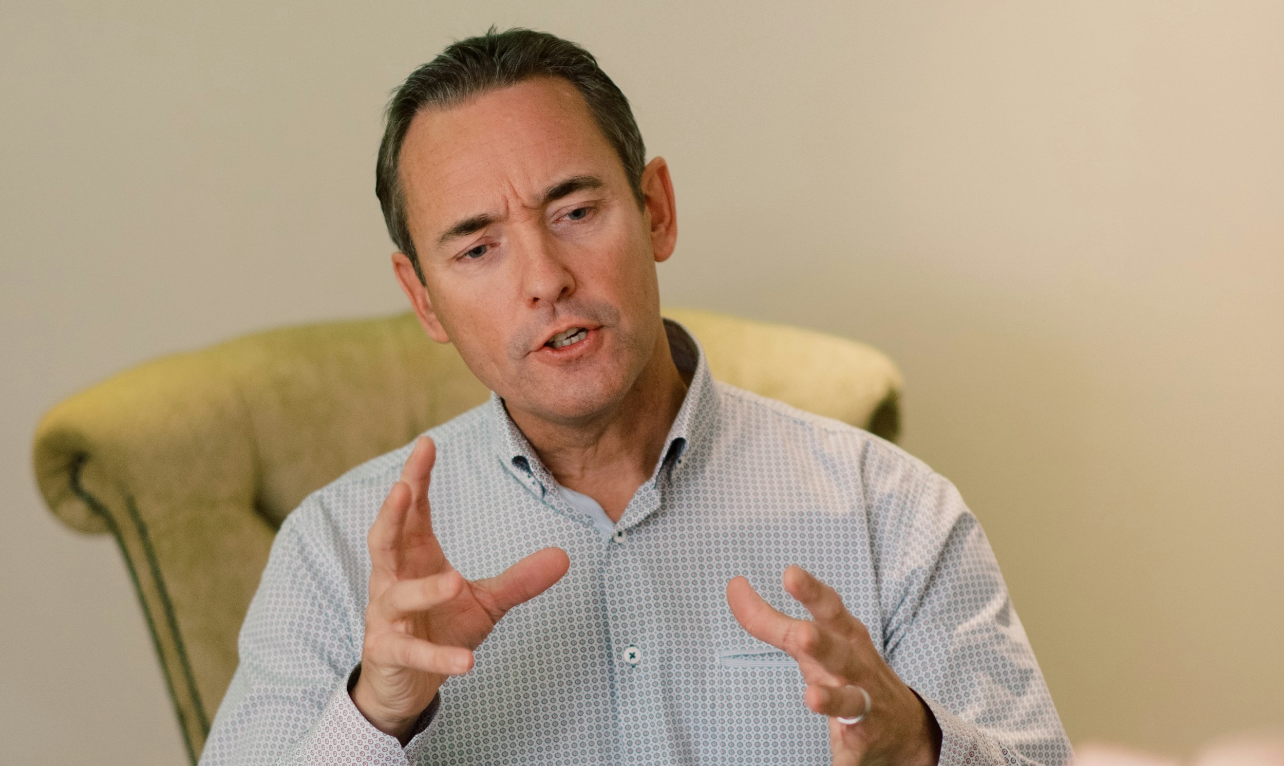 A therapist gestures with his hands as he speaks with his client.
