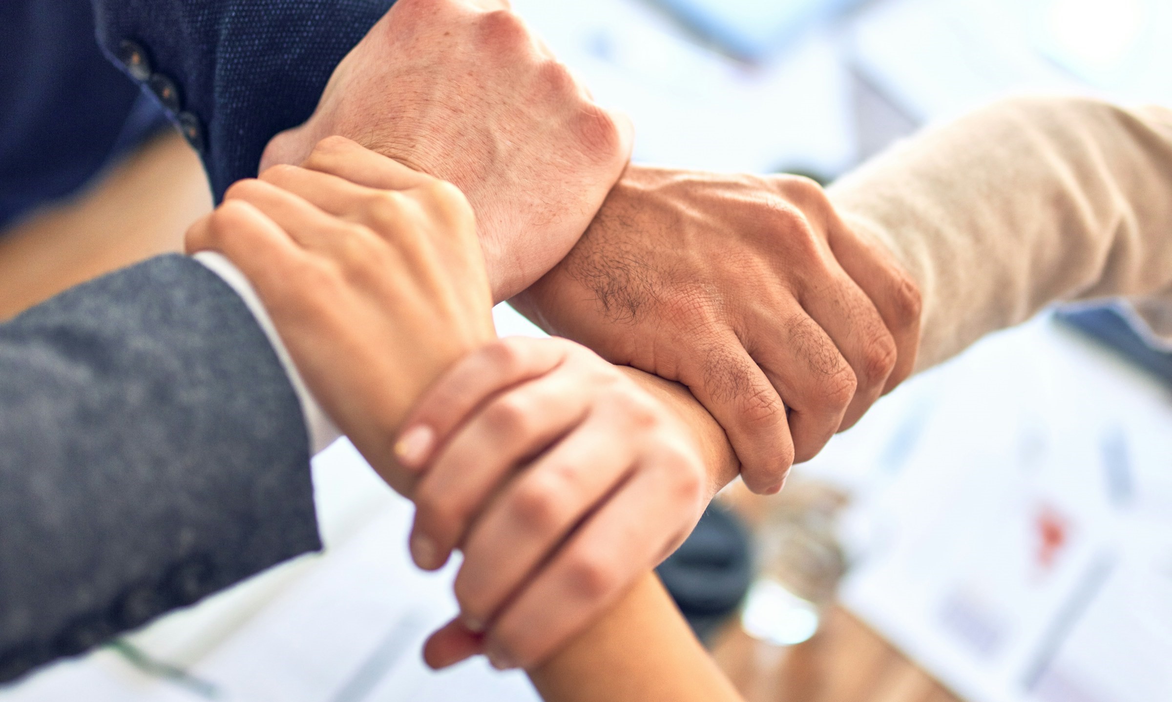 A group of people hold hands in unity.