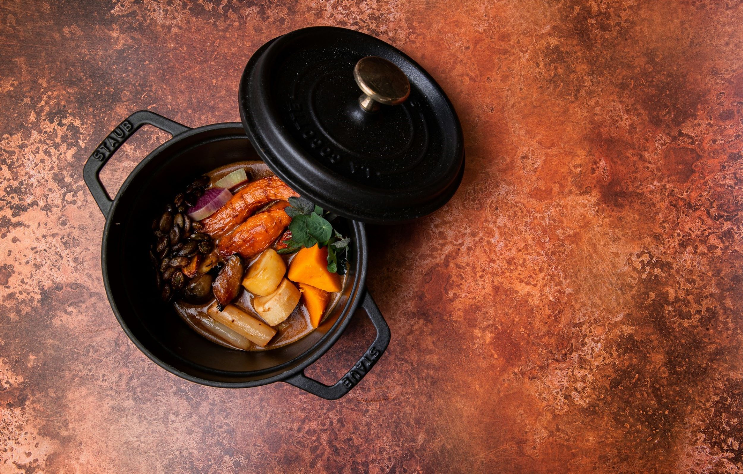 A pot of stew is positioned on a table.