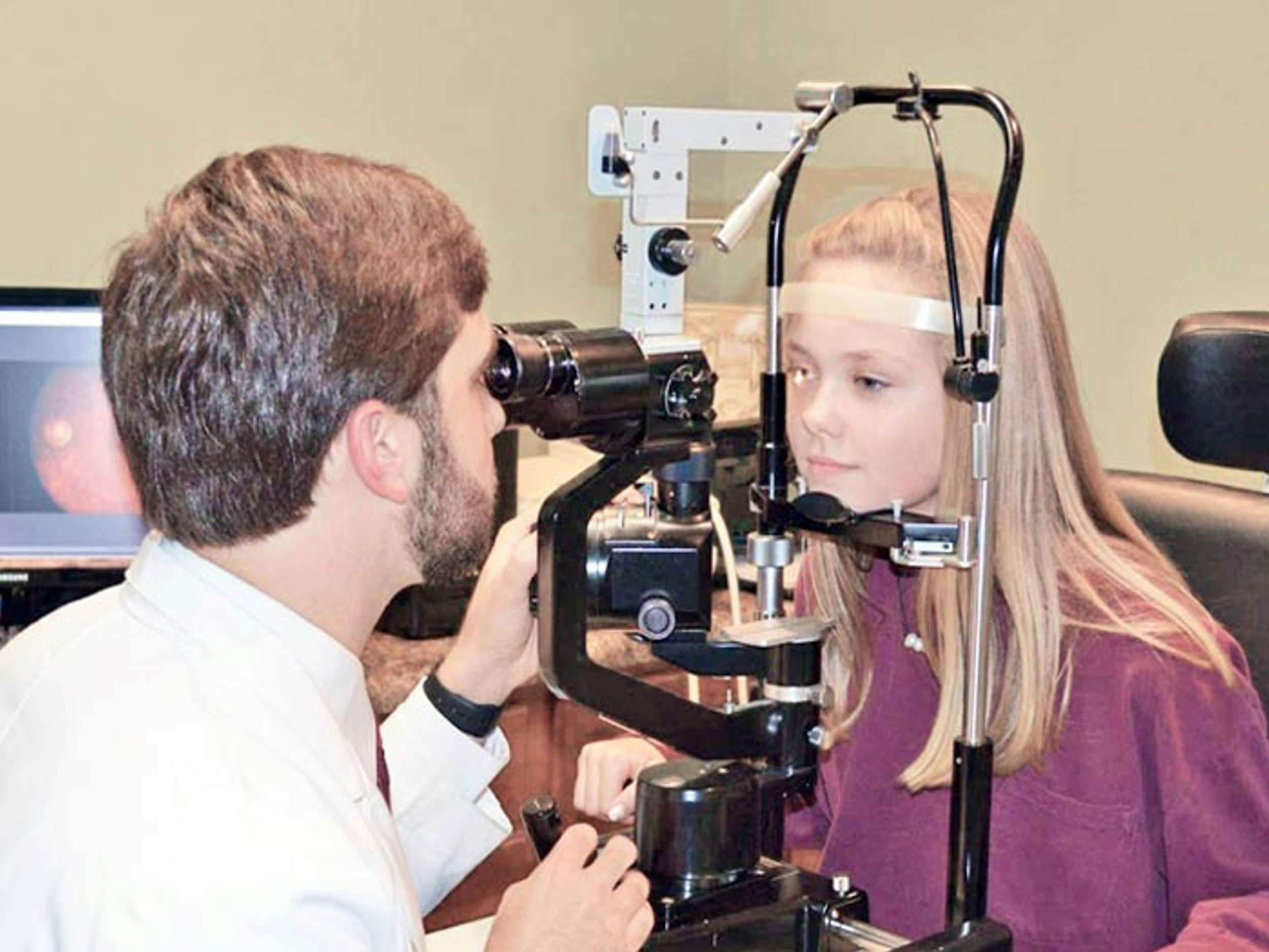 A man conducts an eye exam on a patient.