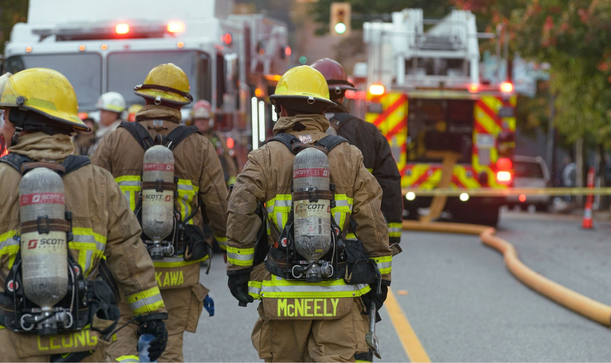 A group of firefighters head toward their fire engine.
