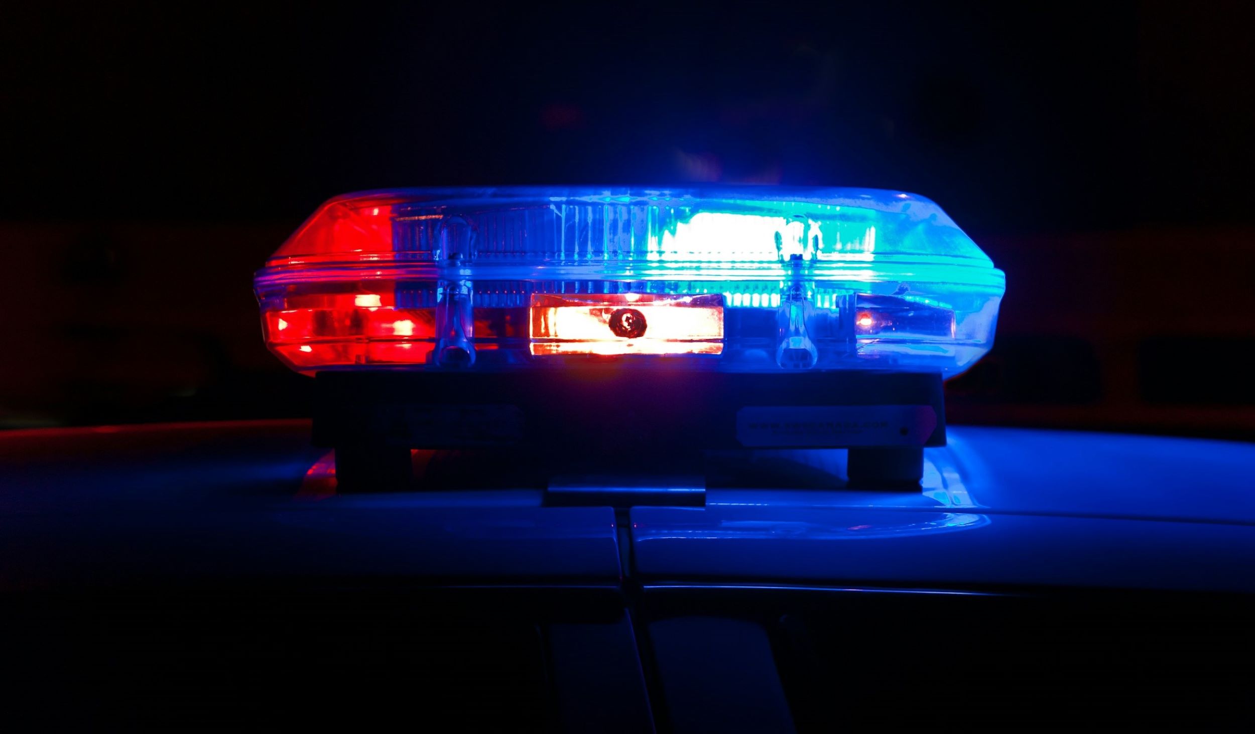 The flashing lights of a police siren glow through the darkness.