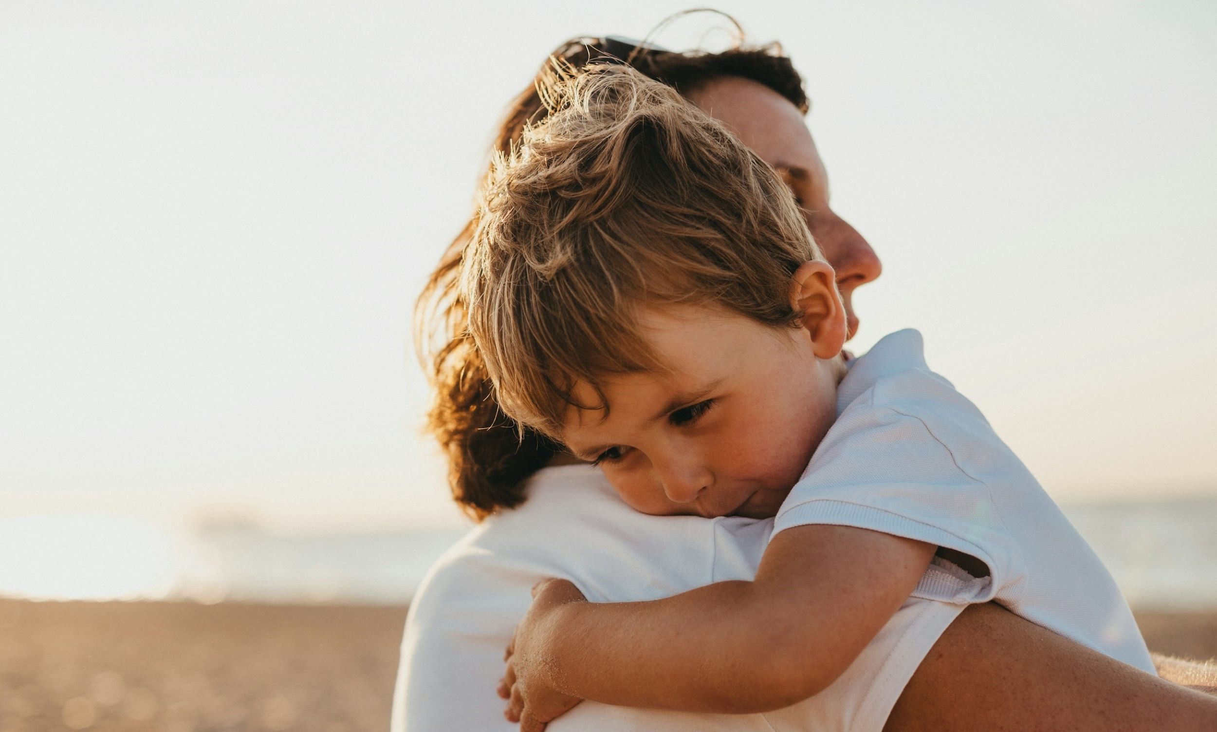 A parent hugs her child affectionately.